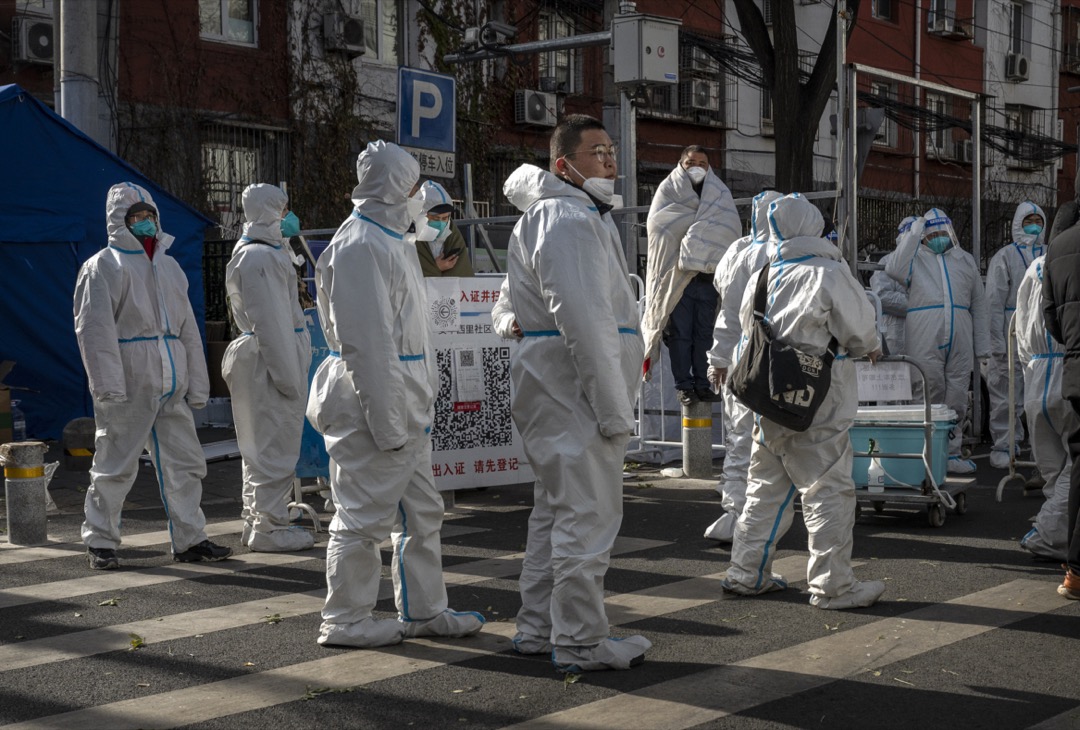 2022年11月29日,中國北京,穿保護衣的街道工作人員準備位一個社區進行消毒。