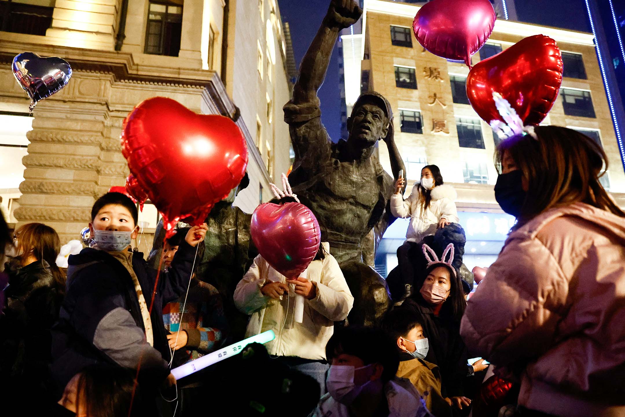 2022年12月31日,湖北省武汉市,疫情期间,人们聚集在一起庆祝新年并举著气球。