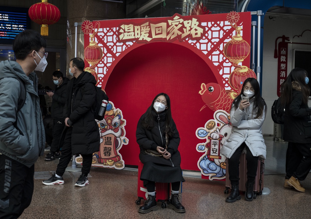 2023年1月20日,中国北京,一名女子坐在一个以新年为主题的背景前面。