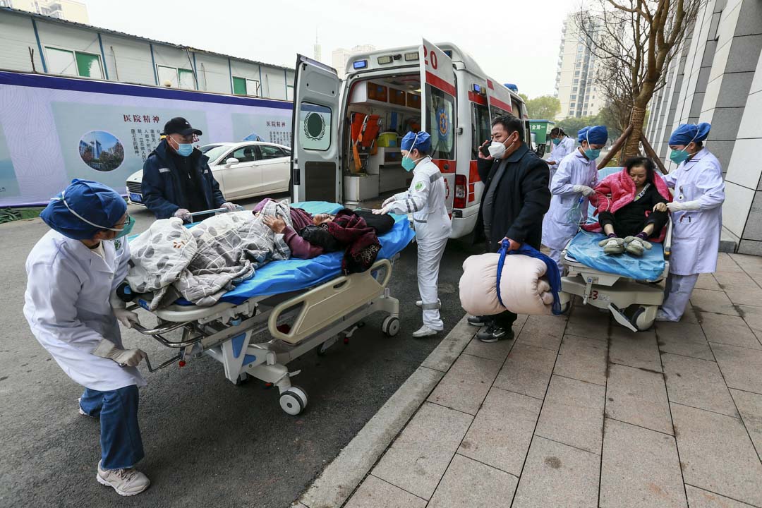 2022年12月31日,中国遂宁市,医护人员协助两位被救护车送往医院的病人。