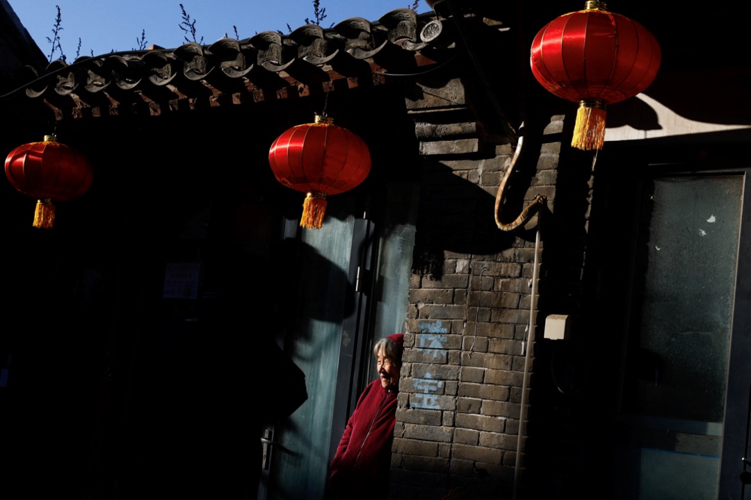 2023年1月15日,中国北京,一名老人家在一个胡同内看灯笼。