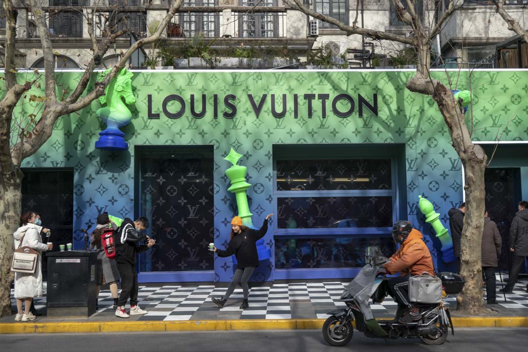 2022年1月14日,中國上海,一名女士在在奢侈品品牌路易·威登(Louis Vuitton)店前擺姿勢拍照。