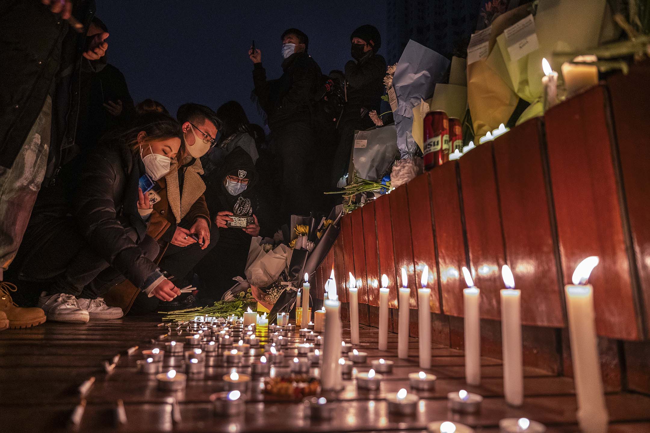 2022年11月27日,北京,為悼念烏魯木齊大火死難者,市民在追悼期間點燃蠟燭。