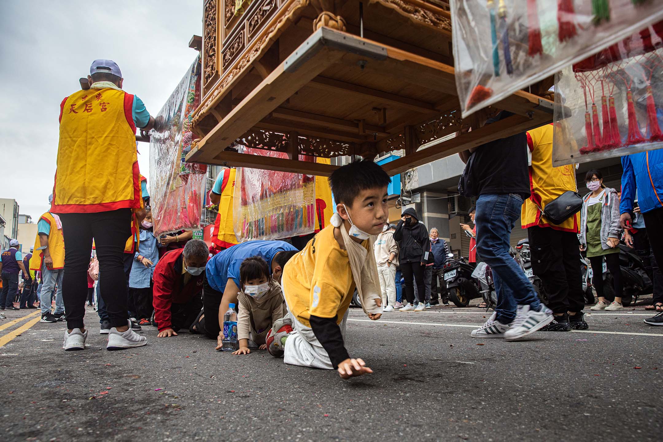 2023年2月5日,台东,遶境期间,民众钻轿脚祈福。