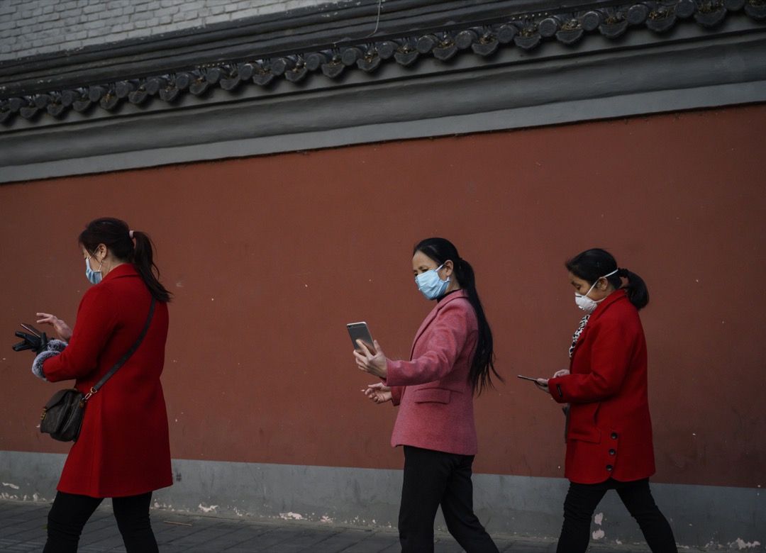 2020年4月22日,中国北京,数名女子在行人路上用电话。