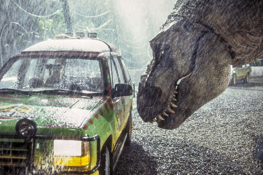 《侏罗纪公园》中游园吉普车无力抵挡 T-Rex 暴龙的蛮力攻击,无从庇护车子里的乘客。