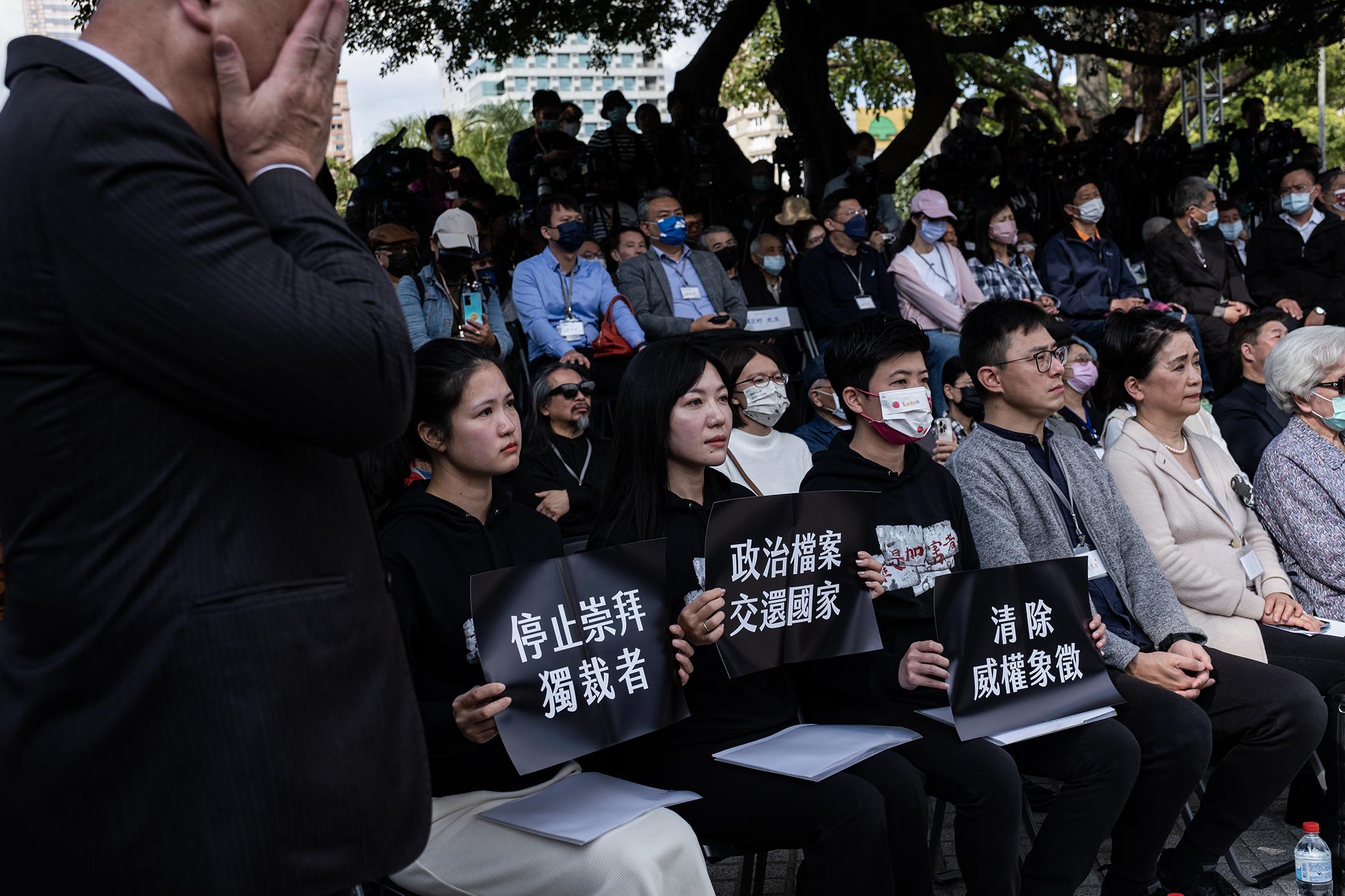 2023年2月28日,台北二二八和平纪念公园,台北市议员林亮君、吴沛忆、苗博雅等人,穿上“谁是加害者”的黑衣,出席台北市二二八纪念仪式,并分持“清除威权象征”、“停止崇拜独裁者”、“政治档案交还国家”的黑色纸板,坐在贵宾席上。