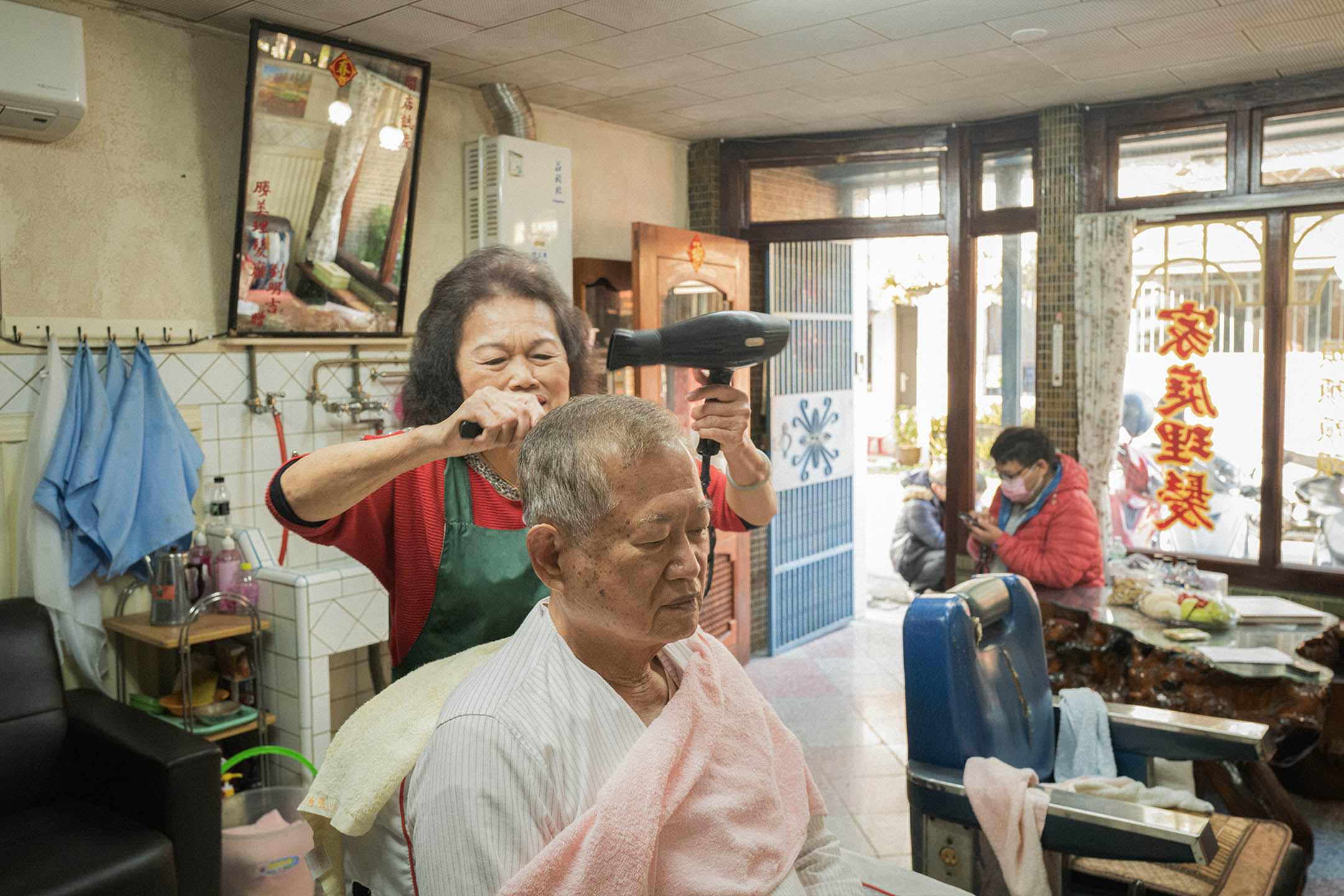 2023年2月27日,台中,阿蕊理发店,阿蕊为老邻长何先生剪发。