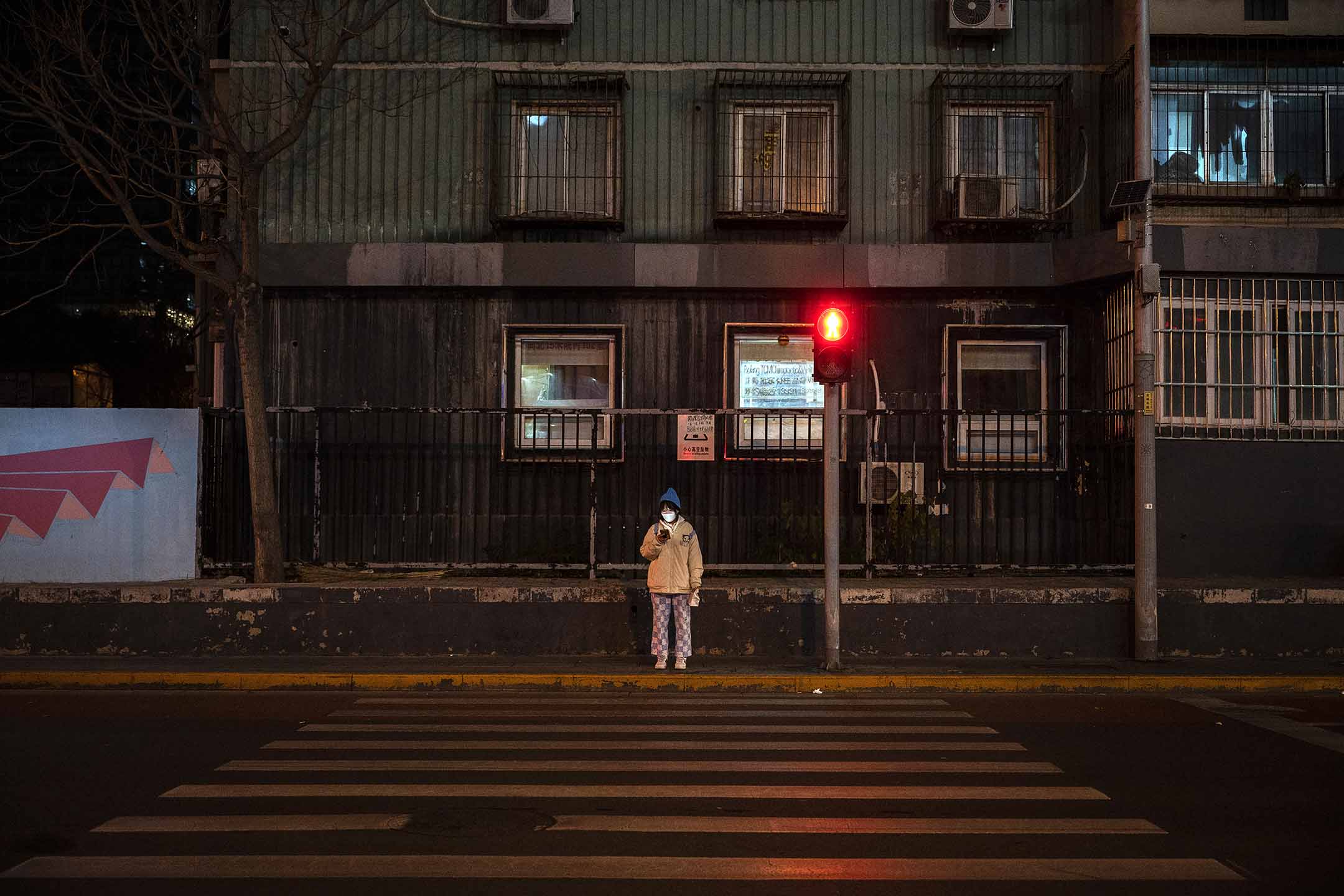 2022年11月22日,北京,一名妇女在空无一人的十字路口。