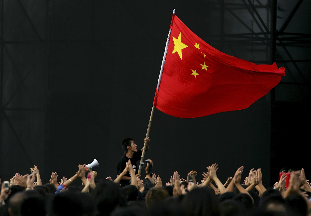 2005年10月2日,中國北京舉行的搖滾音樂節期間,一名少年揮舞著國旗,以紀念國慶。攝:Guang Niu/Getty Images
