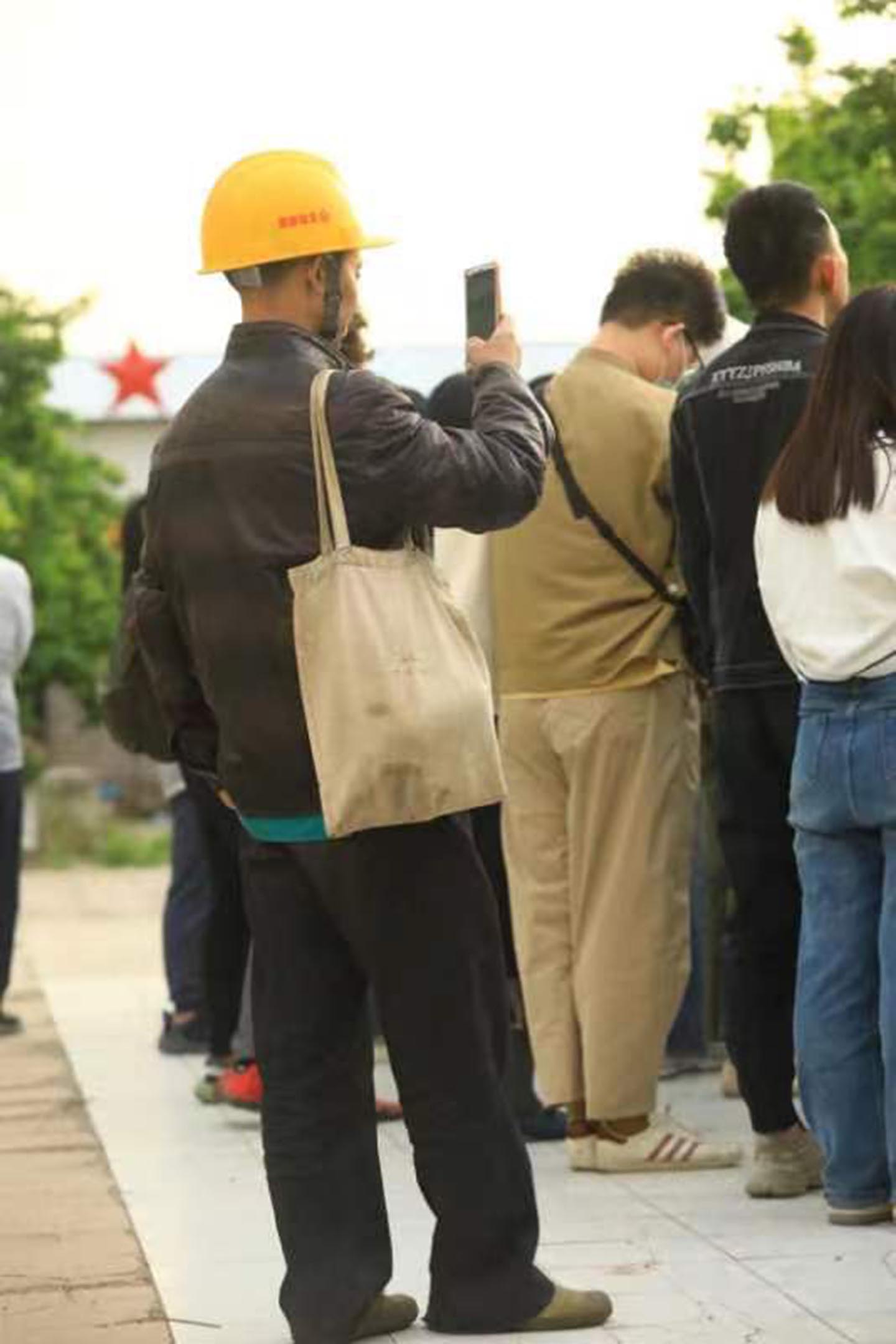 一個工人在用手機拍攝告別式。攝影:網友“沖繩流浪貓”