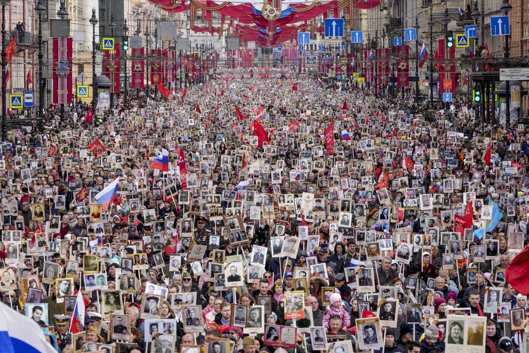 2022年5月9日,俄羅斯聖彼得堡中央大道涅瓦大街的不朽軍團遊行期間,人們舉著參加過二戰的親屬畫像,以紀念第二次世界大戰結束 77 週年。攝:Dmitri Lovetsky/AP/達志影像