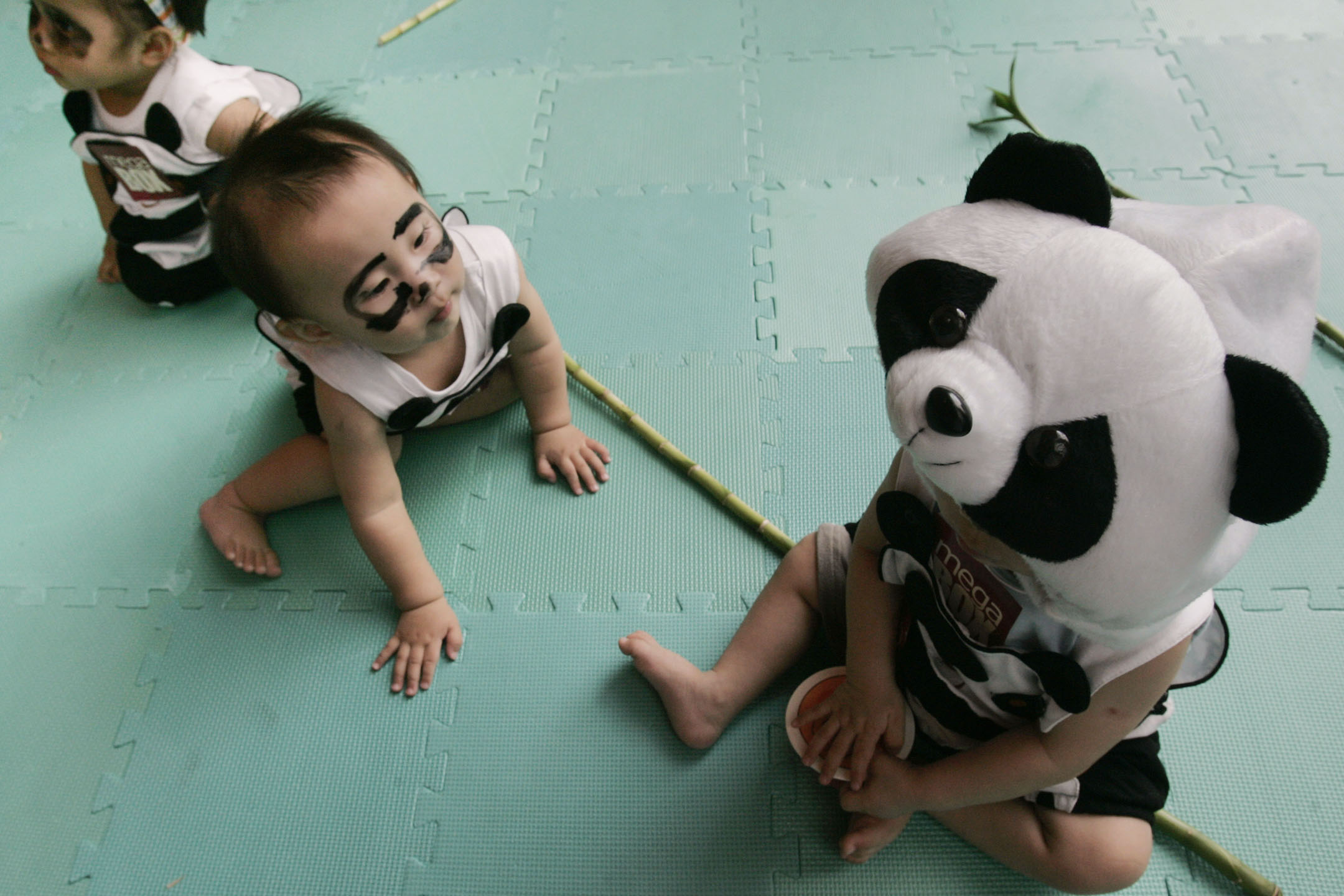 2007年6月21日,香港一家購物中心的促銷活動,打扮成熊貓的嬰兒在舞台上玩耍。攝:Paul Yeung/Reuters/達志影像