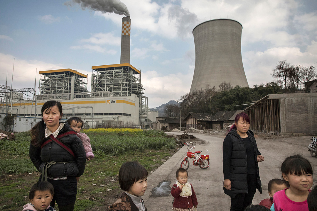2017年2月7日，中國六盤水市，村民站在燃煤發電廠前。攝：Kevin Frayer/Getty Images