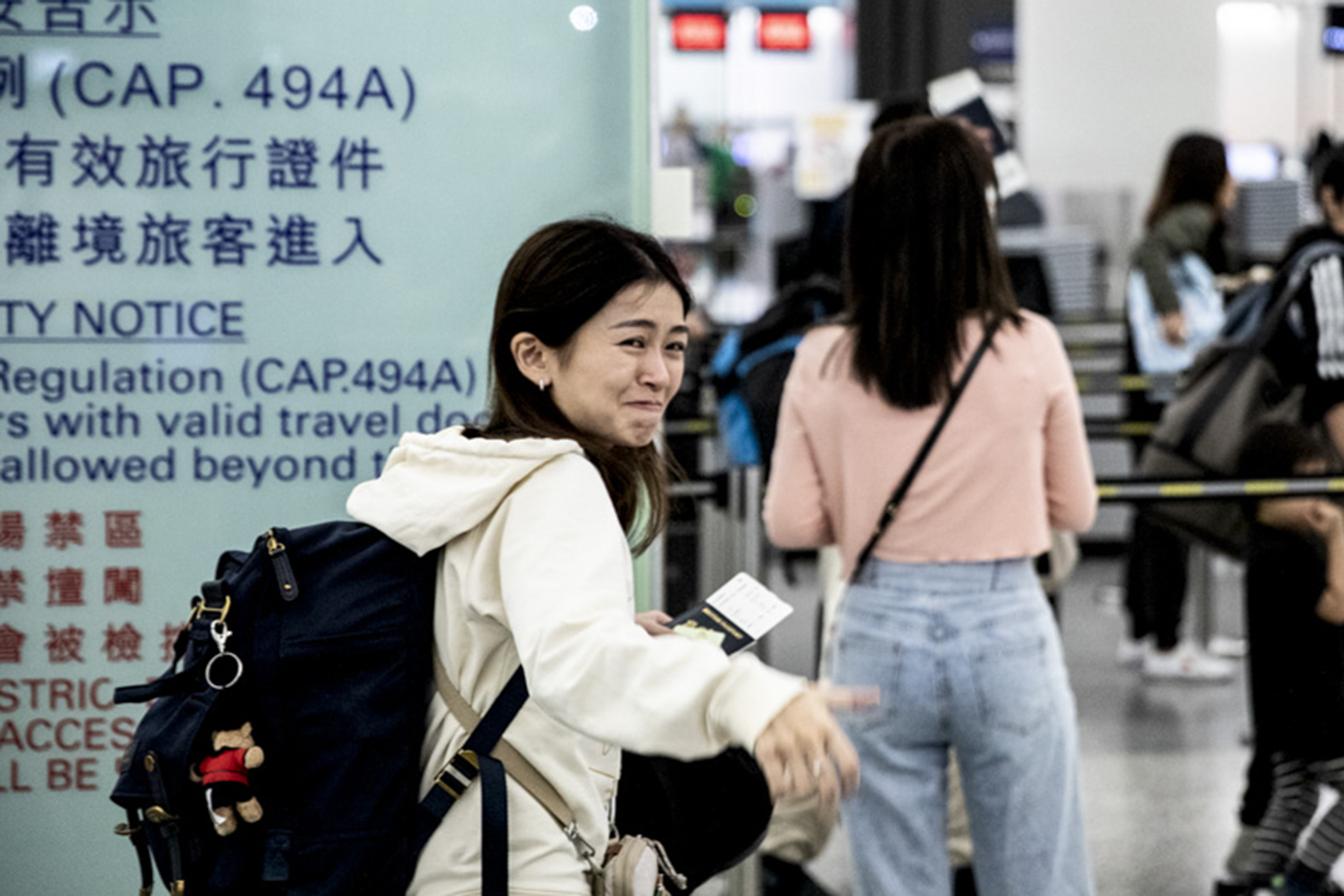 2023年4月26日晚上,张子君在离港闸口前向送行的亲友挥手道别。摄:林振东/端传媒