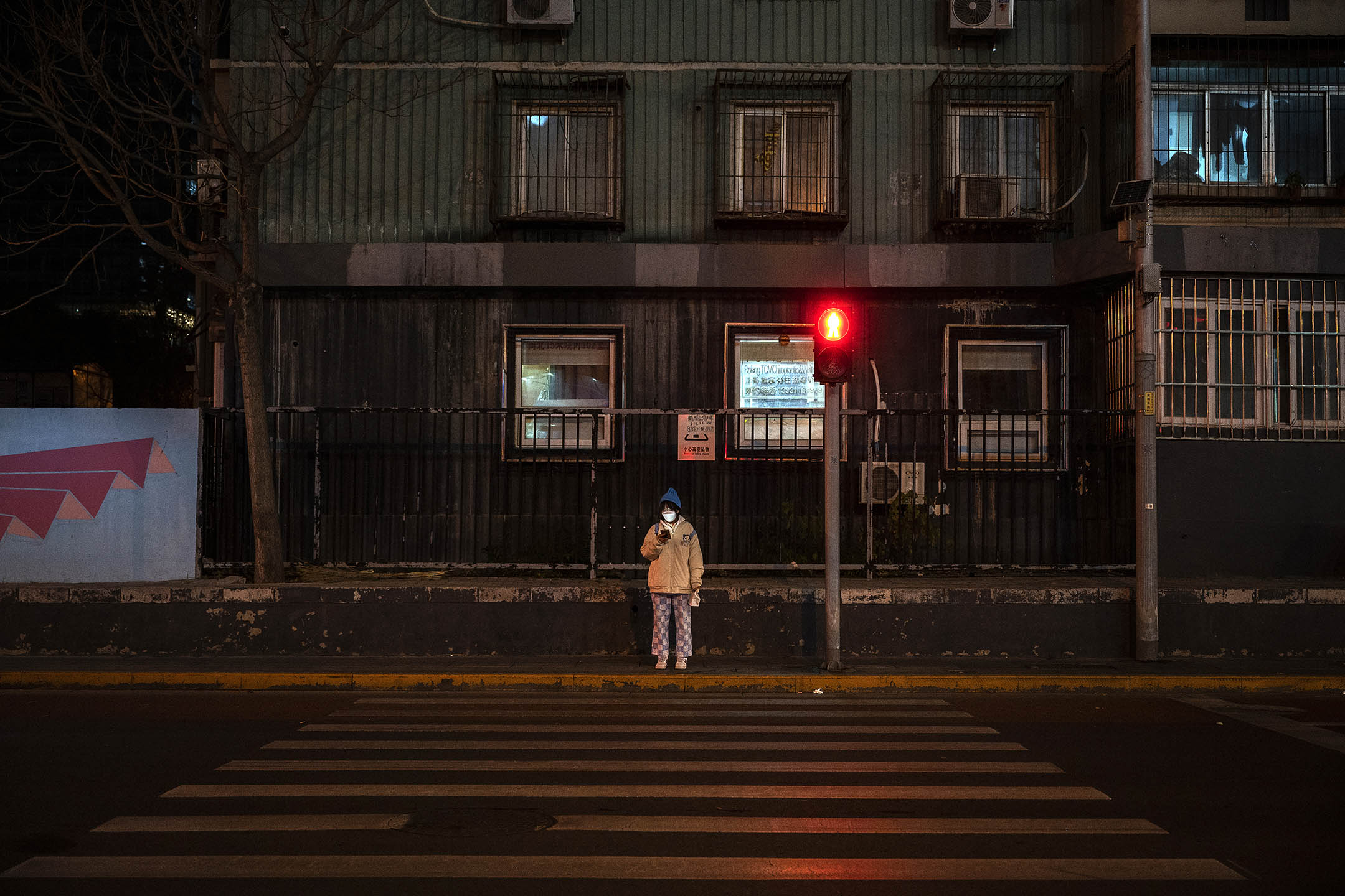 2022年11月22日，北京，一名婦女走過一條空無一人的道路。攝：Kevin Frayer/Getty Images
