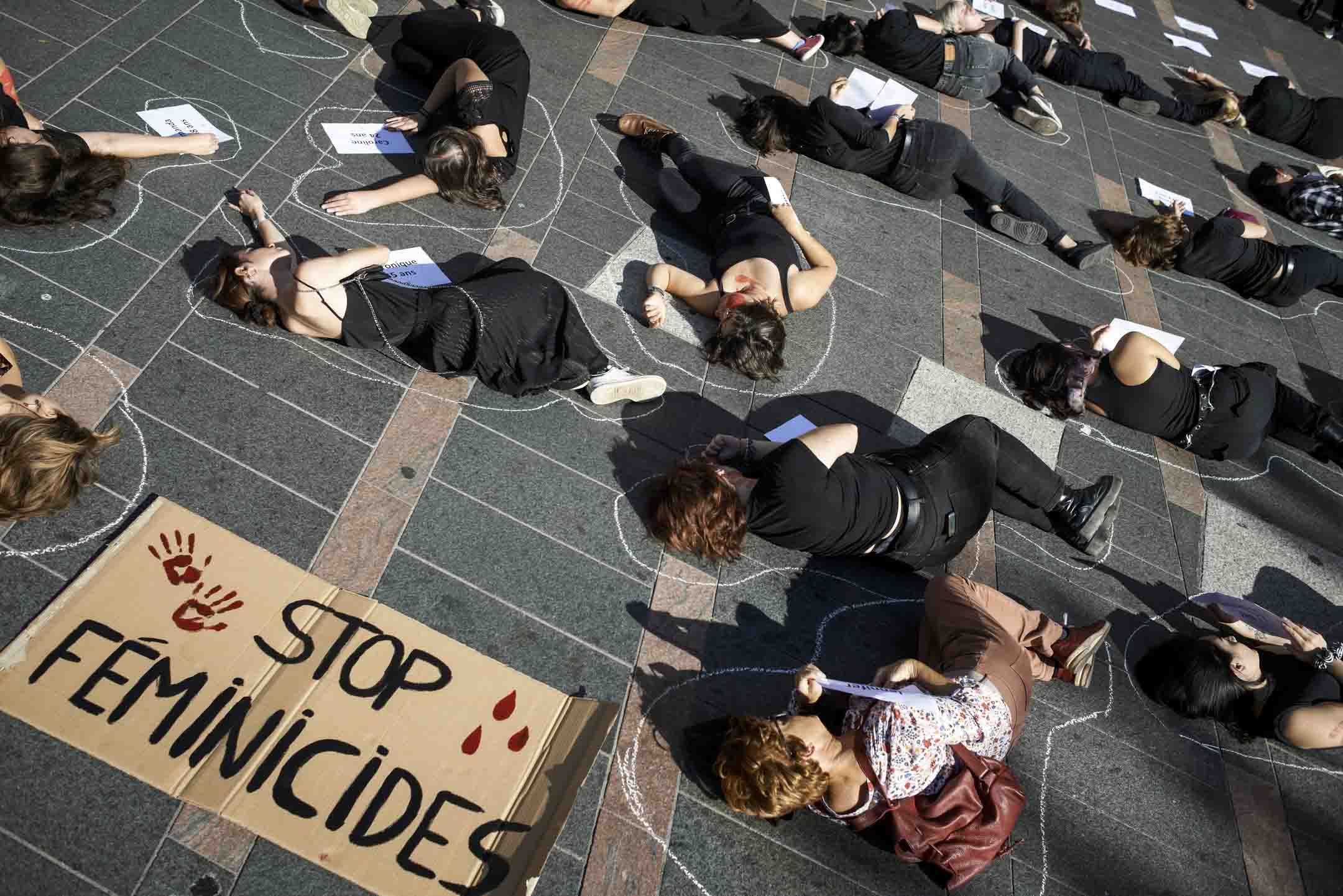 2022年10月22日,法國圖盧茲,女性團體請願呼籲停止女性暴力,現場有床單上寫著 2022 年遇害女性的姓名和年齡,而女示威者躺在地上。攝:Alain Pitton/NurPhoto via Getty Images