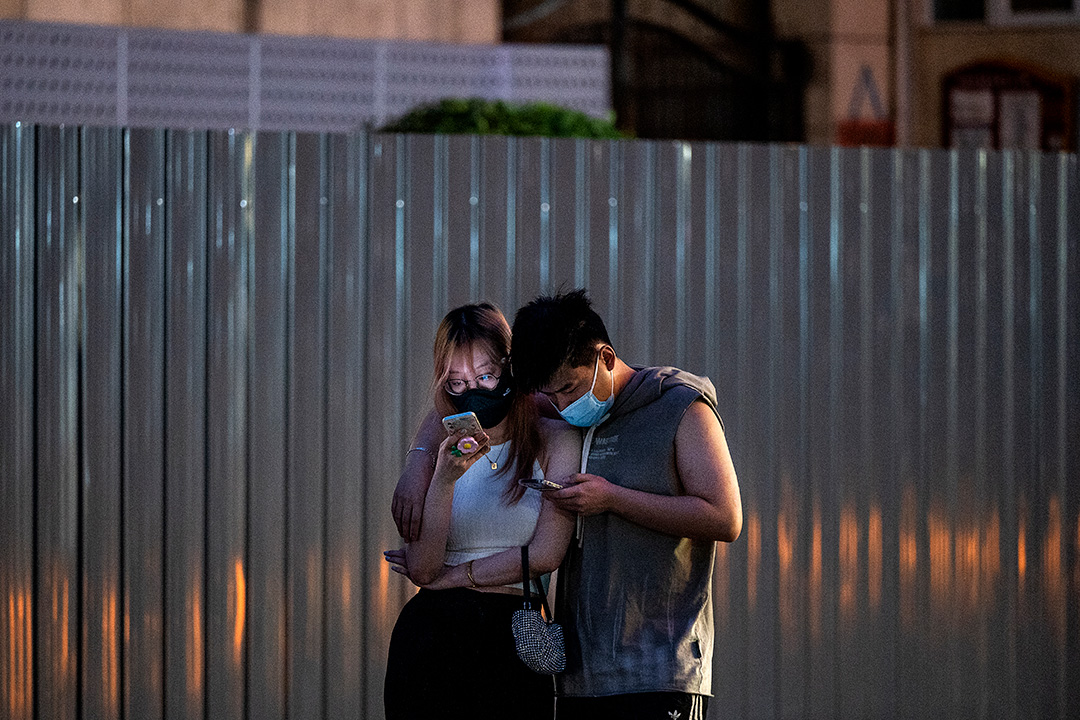 北京街上一雙觀看手機的情侶。攝：Kevin Frayer/Getty Images