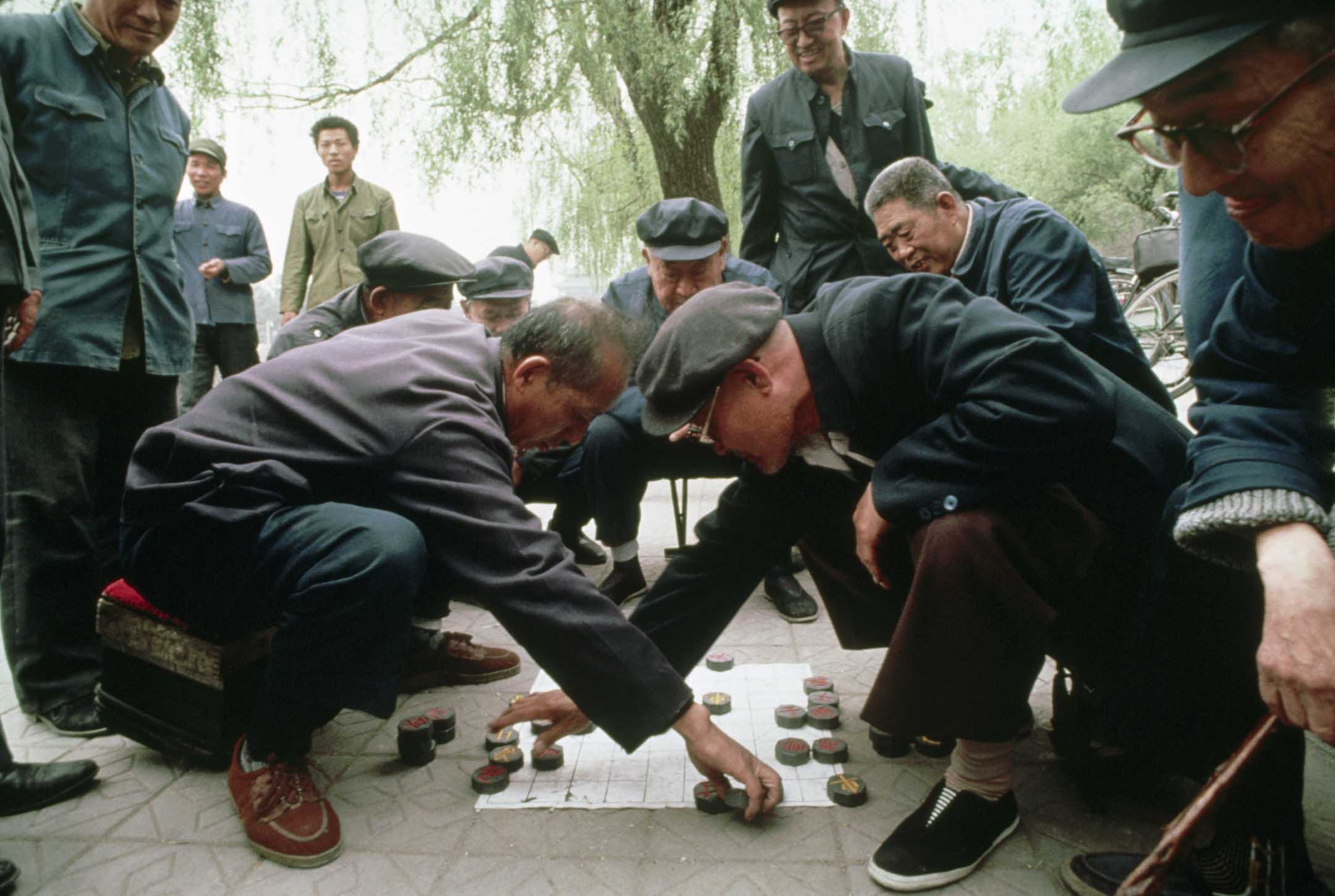 1989年4月日,北京的一个公园里,一群人围著两个下象棋的男人。 欧洲象棋就是源于这种古老的游戏。摄: Turnley/Corbis/VCG via Getty Images