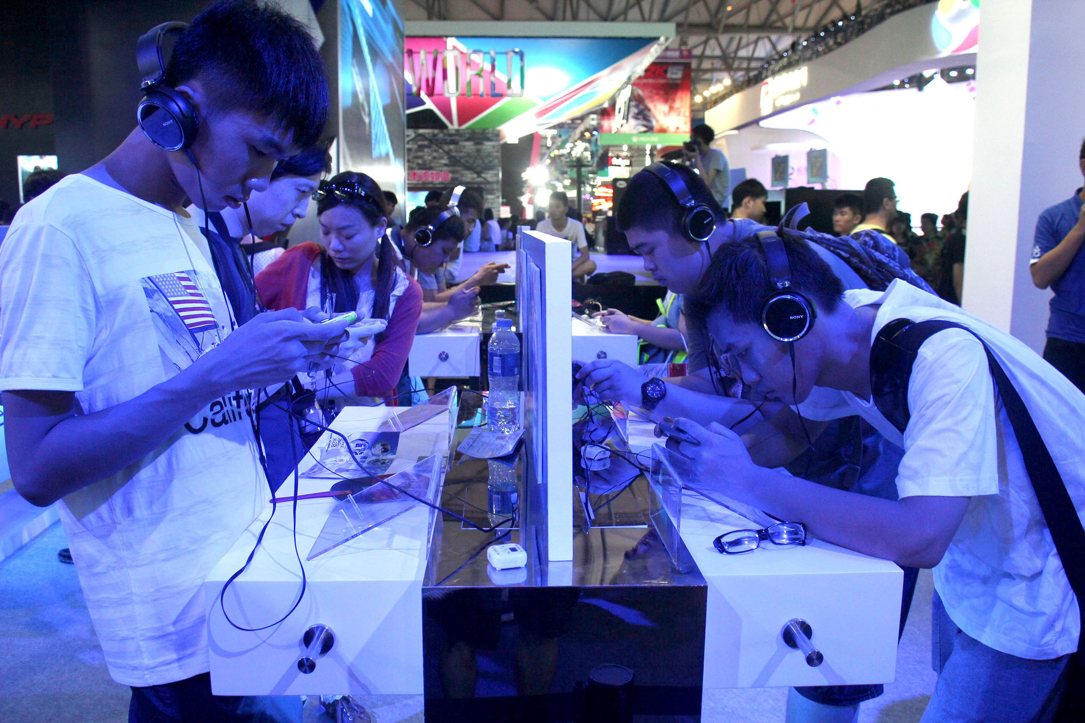 2014年8月1日,中國上海,數名年青人正在博覽會上玩手機遊戲。攝:Visual China Group via Getty Images