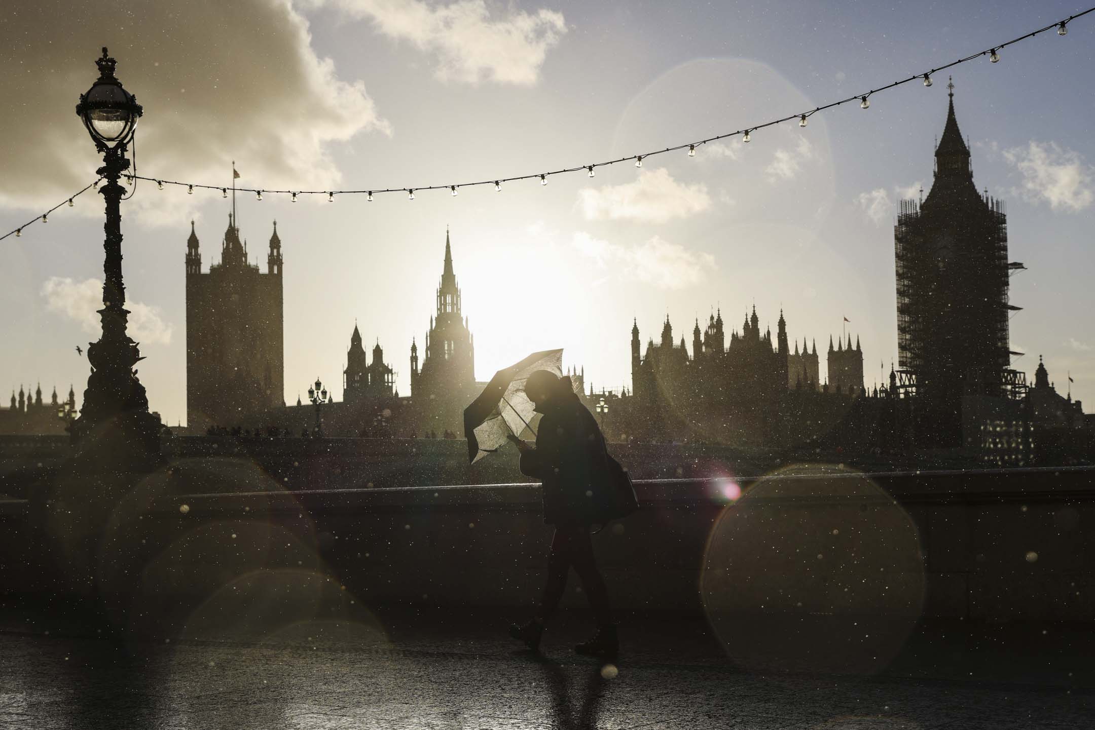 2021年10月31日,英國倫敦,一名行人在雨中沿著南岸行走。攝:Hollie Adams/Getty Images