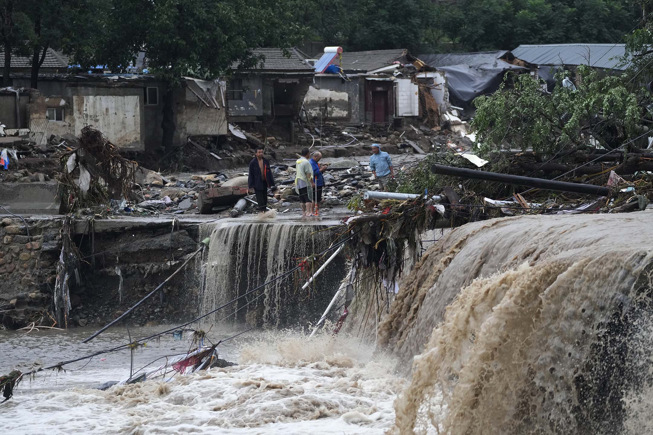 2023年7月31日,北京,连续降雨引发警报,村民聚集在被洪水破坏的村庄附近。摄:Andy Wong/AP/达志影像