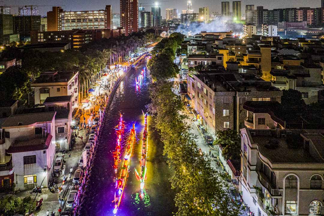 2023年6月19日,中国广东省佛山市,端午节前夕人们在夜间观看龙舟水上巡游。摄:Wu Wenjun/VCG via Getty Images