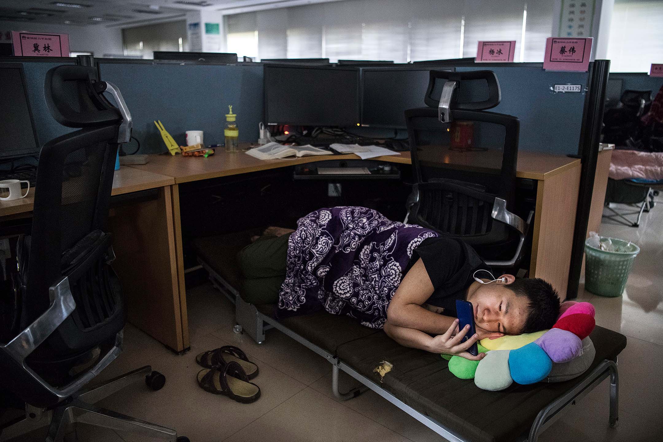 2019年4月12日,中國深圳,一名辦公室員工在休息時間觀看手機。攝:Kevin Frayer/Getty Images