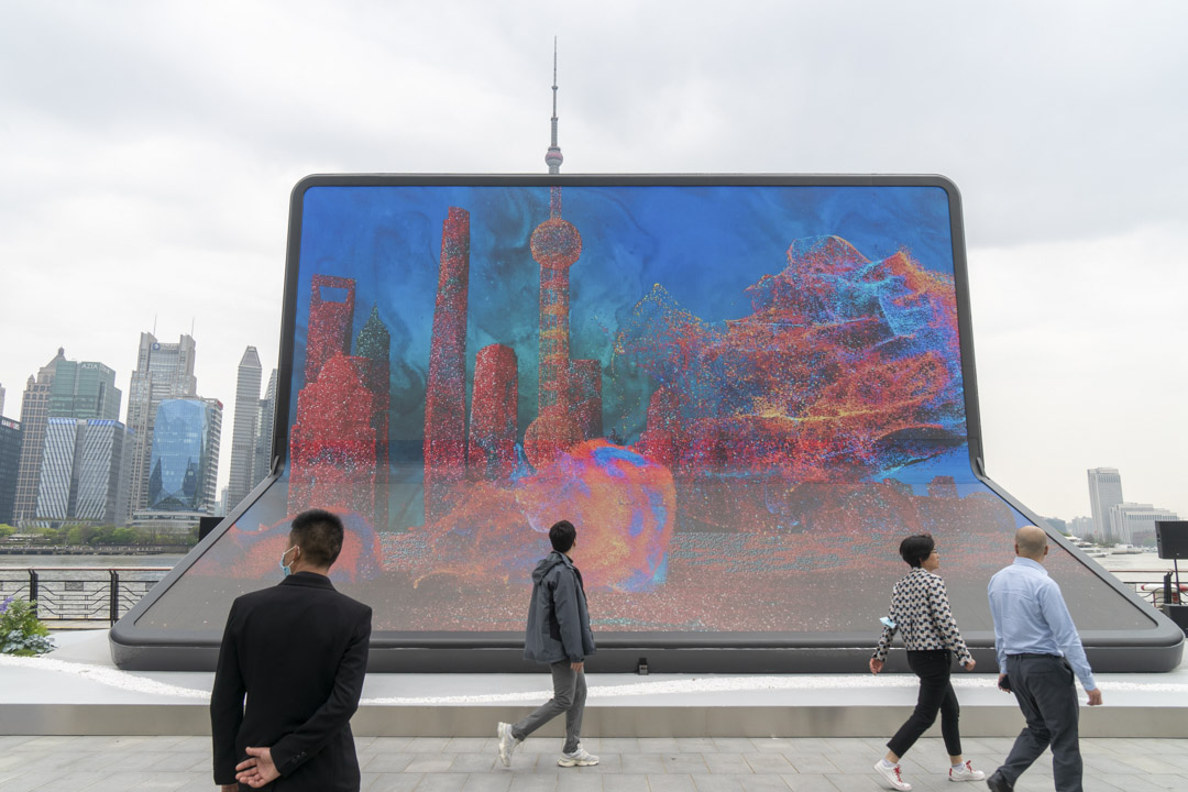 2023年4月11日,中國上海,外灘的人們走過一個大型的廣告板。攝:VCG/VCG via Getty Images