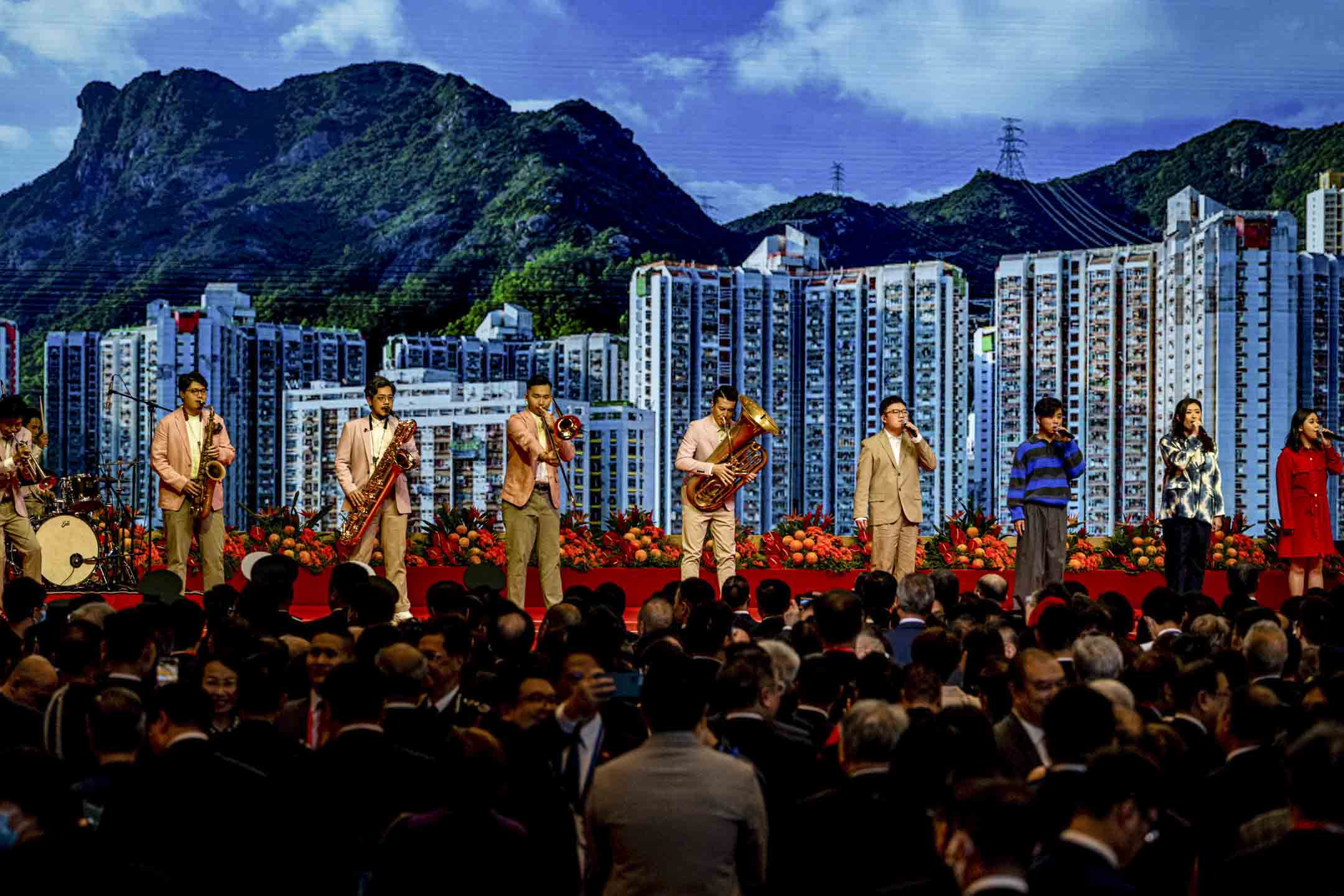2023年7月1日,灣仔會展舉辦慶回歸酒會,有音樂團體在台上演唱,後面背景為獅子山。攝:Ryan Lai/端傳媒