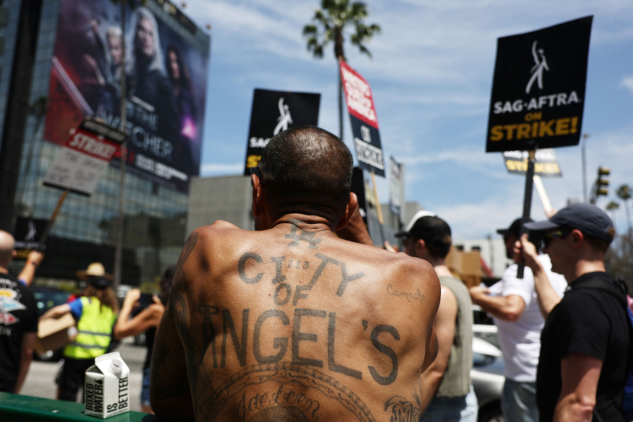 2023年7月21日,美國洛杉磯,一名男子在Netflix總部外觀看遊行隊伍。攝:Mario Tama/Getty Images