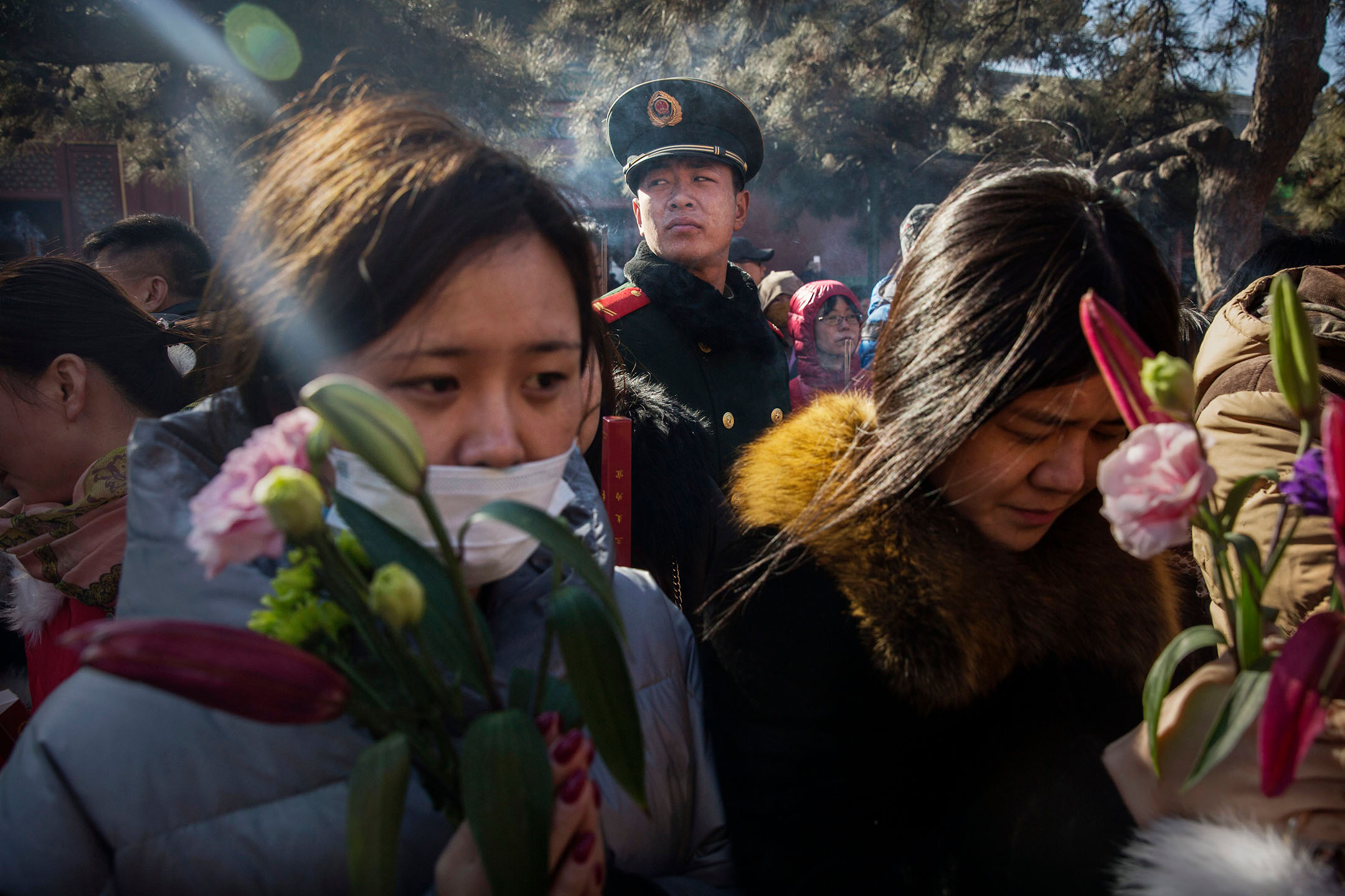 2016年2月8日,中國北京,一名公安在監視著祈禱中的中國信徒。攝:Kevin Frayer/Getty Images