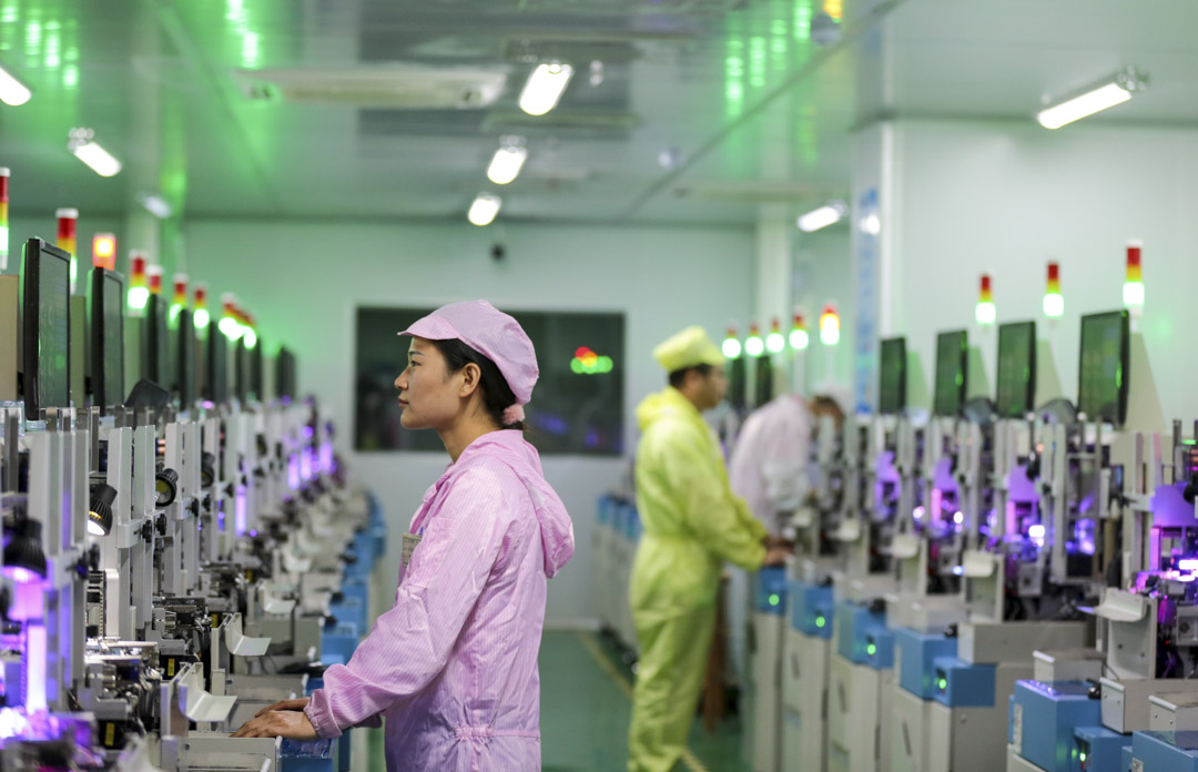 2022年3月17日,中国江西省一家工厂的员工在半导体光电器件生产线上工作。摄:Wei Dongsheng/VCG via Getty Images