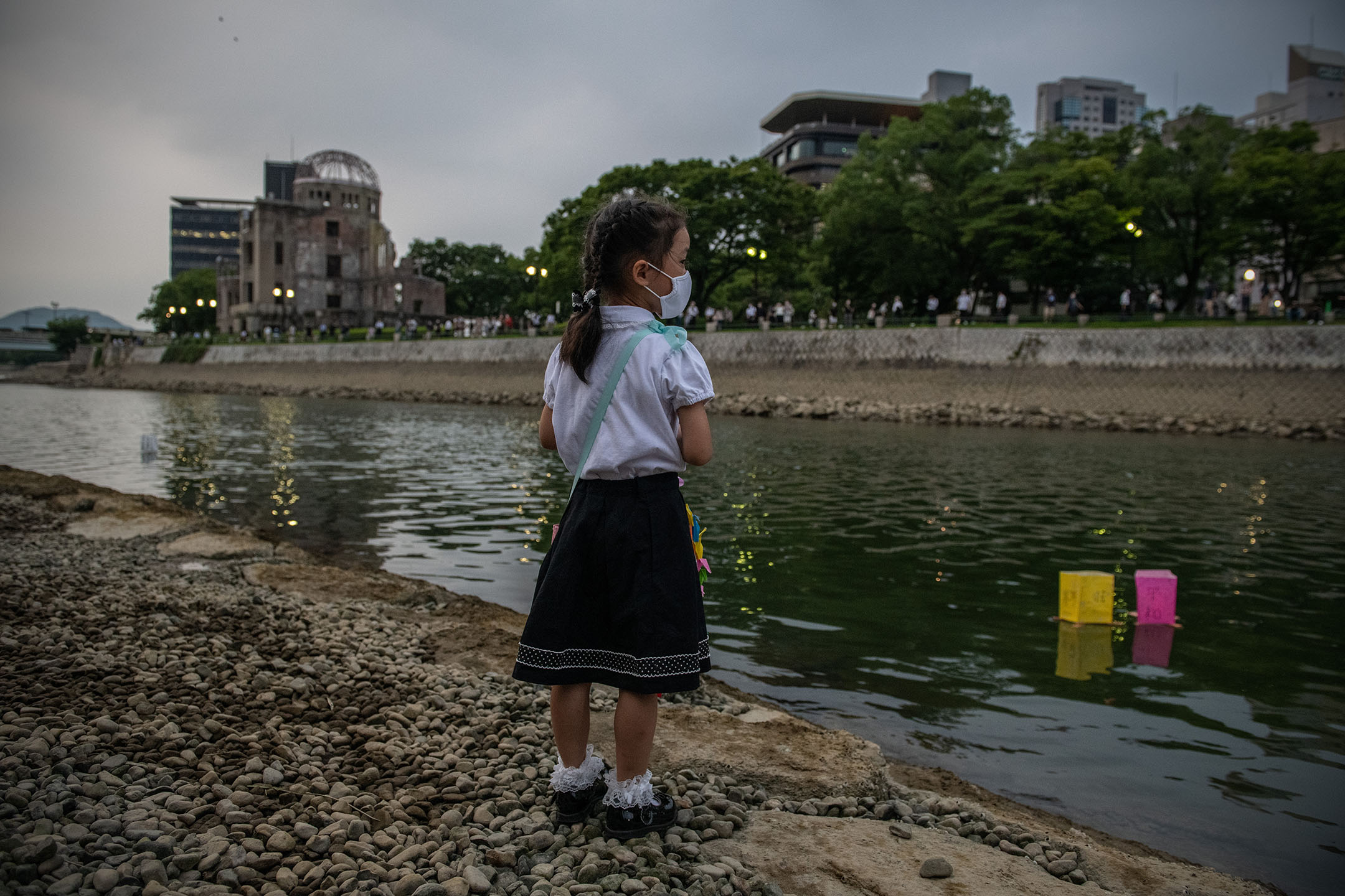 2020年8月6日,一名小女孩站岸邊,看著河上漂浮的燈籠。攝:Carl Court/Getty Images