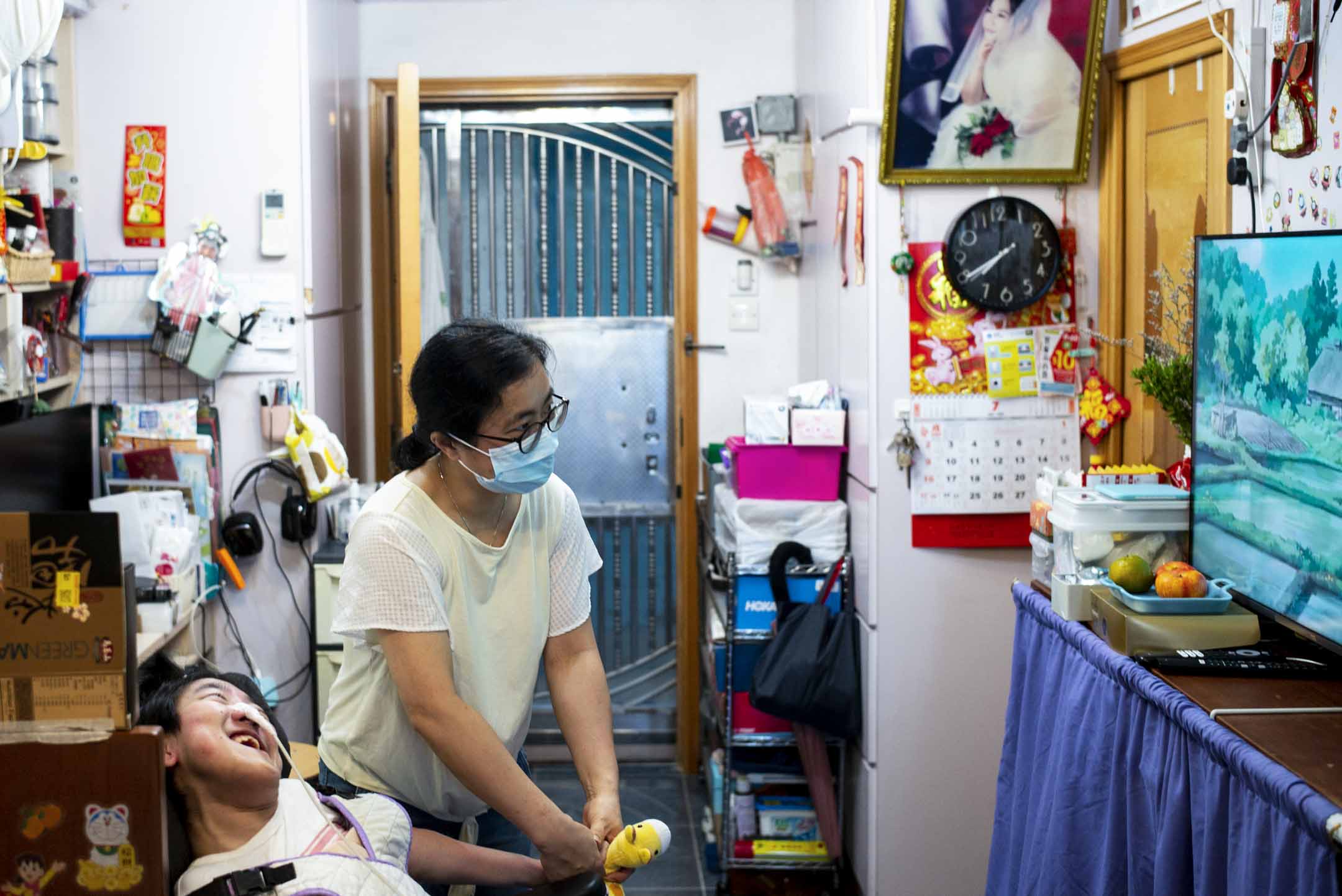 媽媽打開電視給綺琪看。攝:林振東/端傳媒