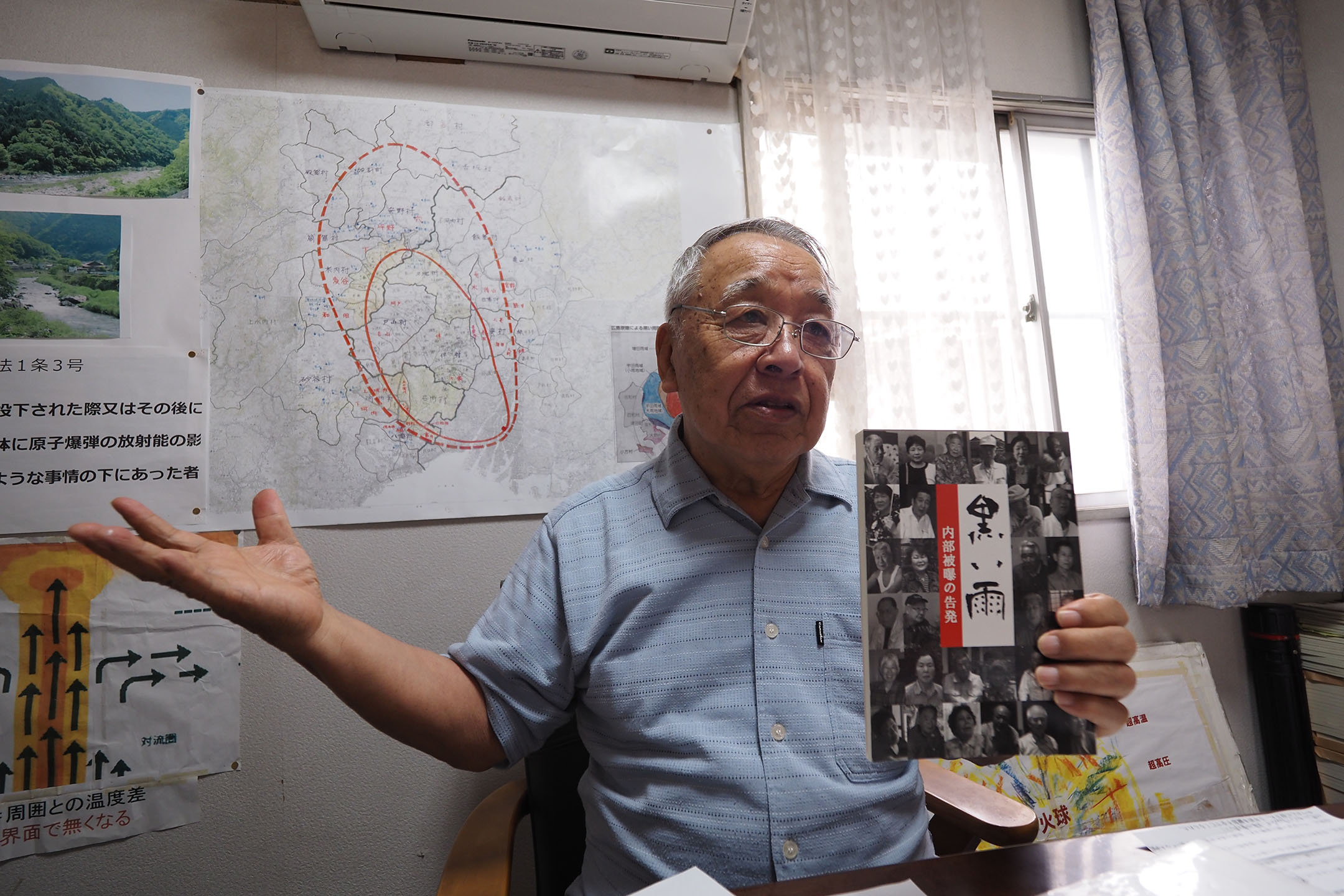 高東征二先生手上的書,是他和夥伴們親自拜訪各地方的黑雨受害者,將大家的經歷記錄下來的作品。攝:王子豪(作者提供)