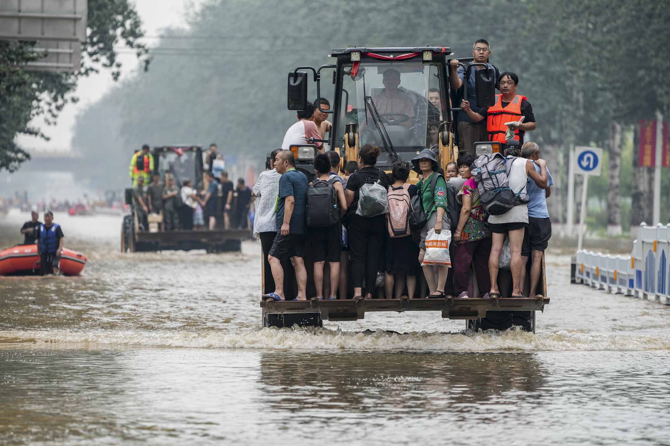 2023年8月2日,中国河北涿州连日倾盆大雨,救援人员使用前置装载机转移被困市民。摄:Cui Nan/China News Service/VCG via Getty Images
