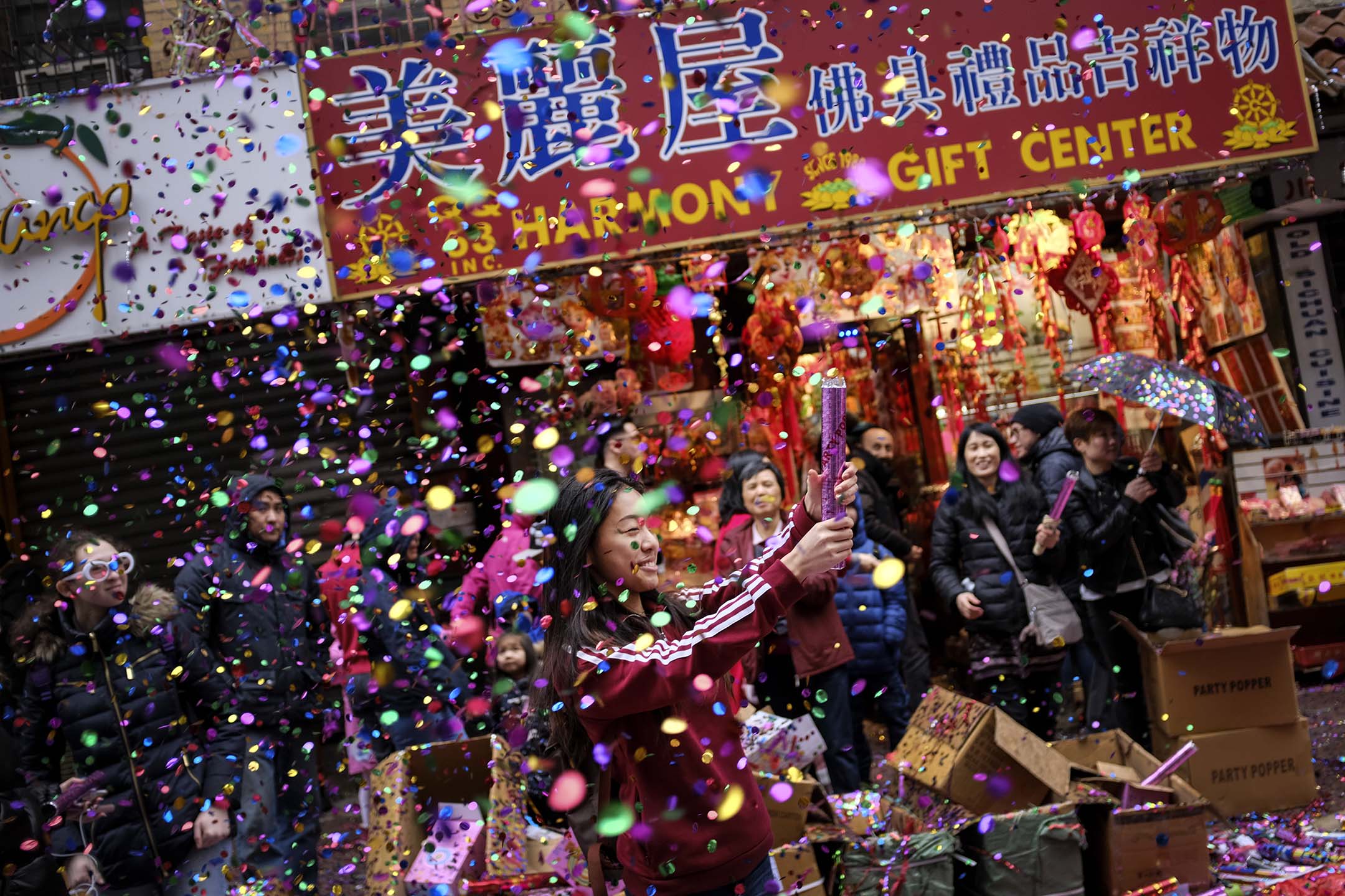 2018年2月16日,紐約市曼哈頓唐人街,一名婦女在慶祝農曆新年期間彈出五彩紙屑。攝:Drew Angerer/Getty Images