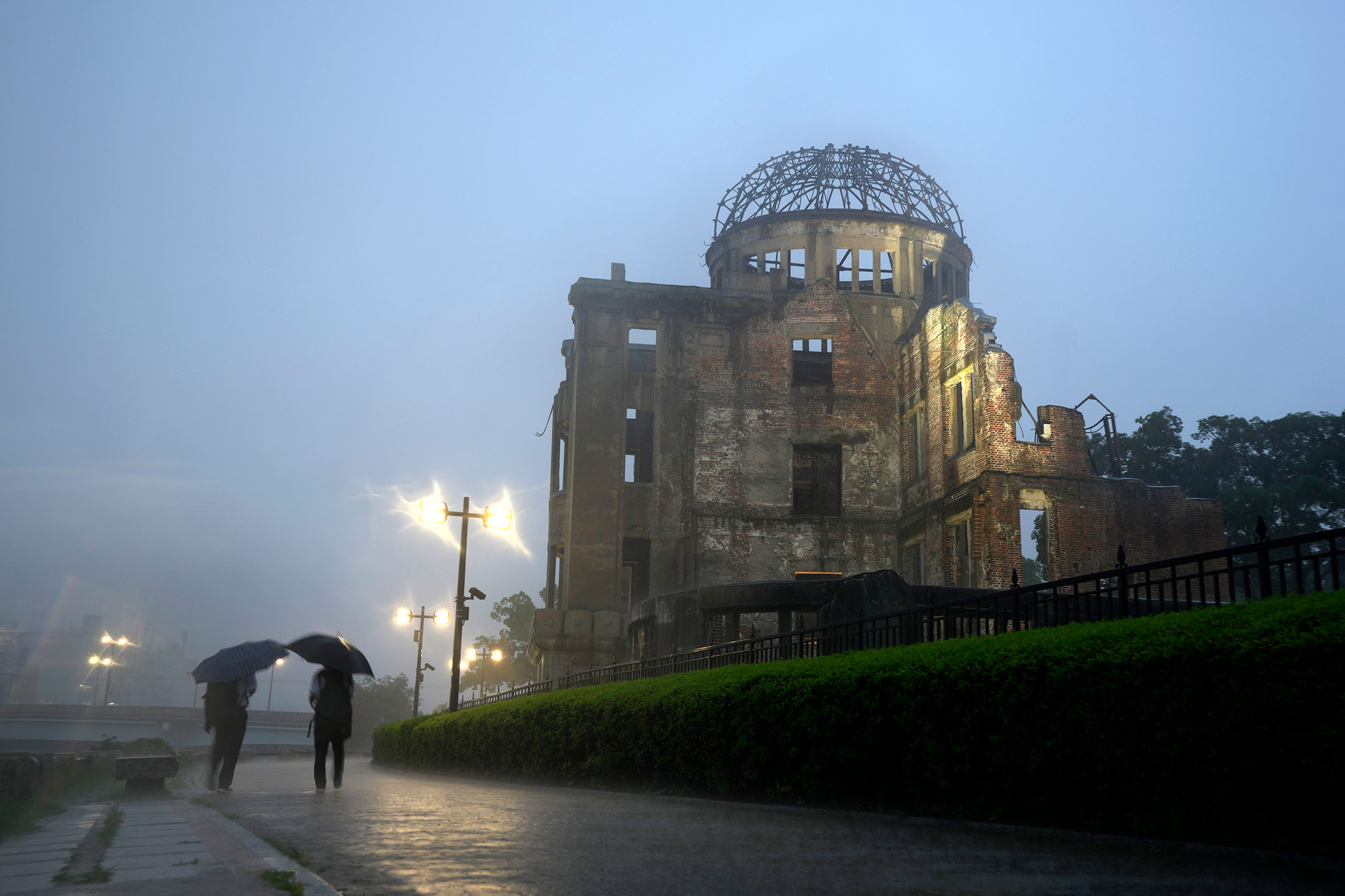 2021年7月15日,日本廣島,兩名男人在雨中行走。攝:Eugene Hoshiko/AP/達志影像