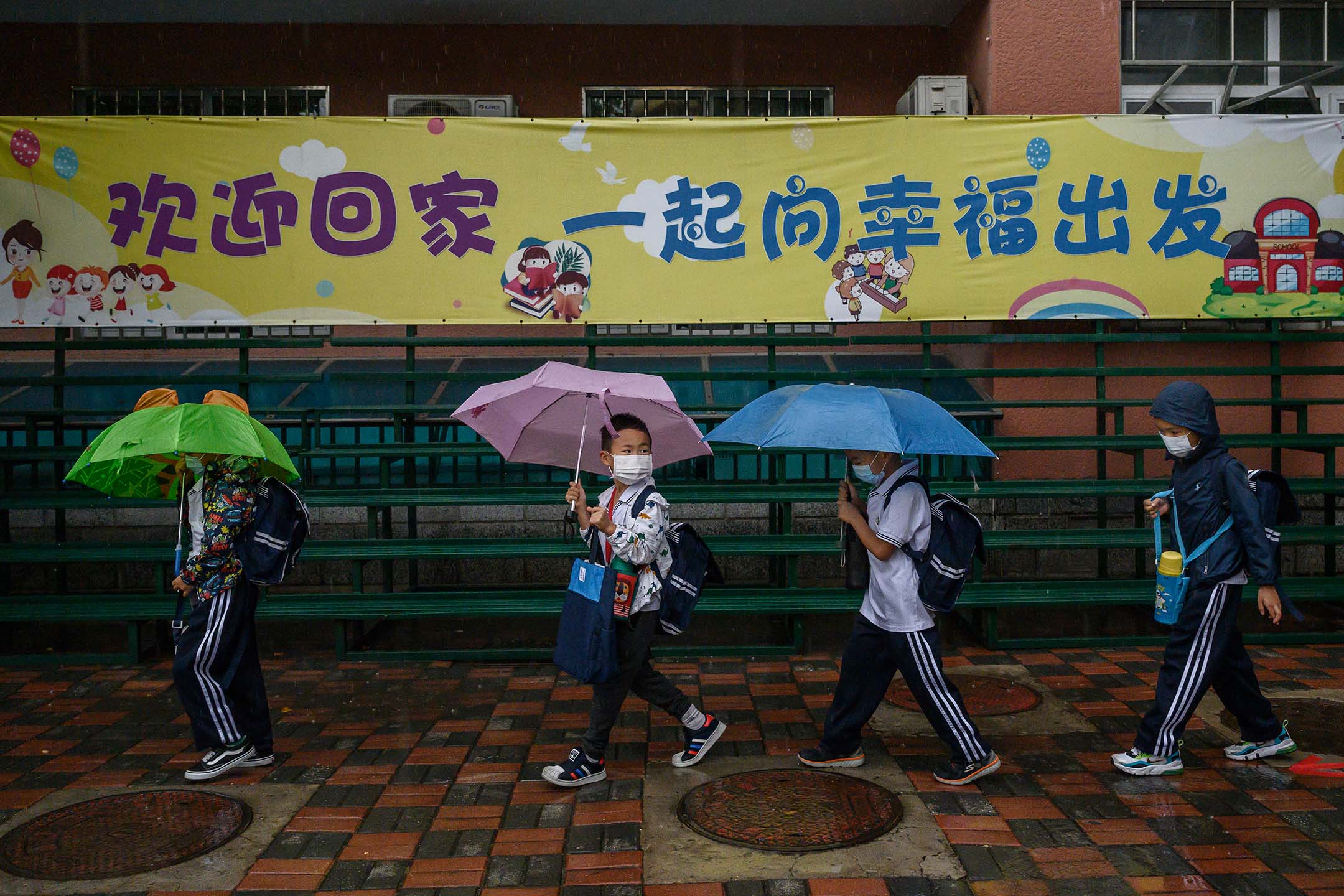 2020年9月23日,中國北京,學生們冒著大雨到學校上課。攝:Kevin Frayer/Getty Images