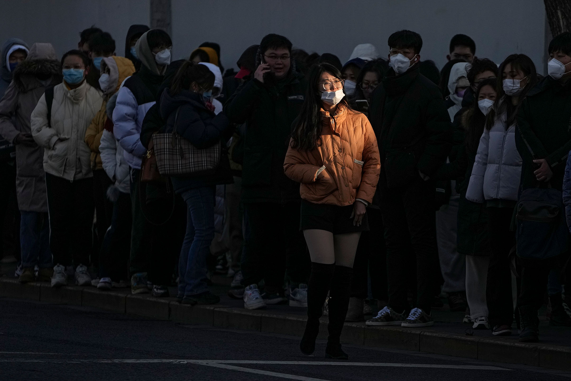 2023年2月13日,中国北京,一名女子在街道上经过。摄:Andy Wong/AP/达志影像