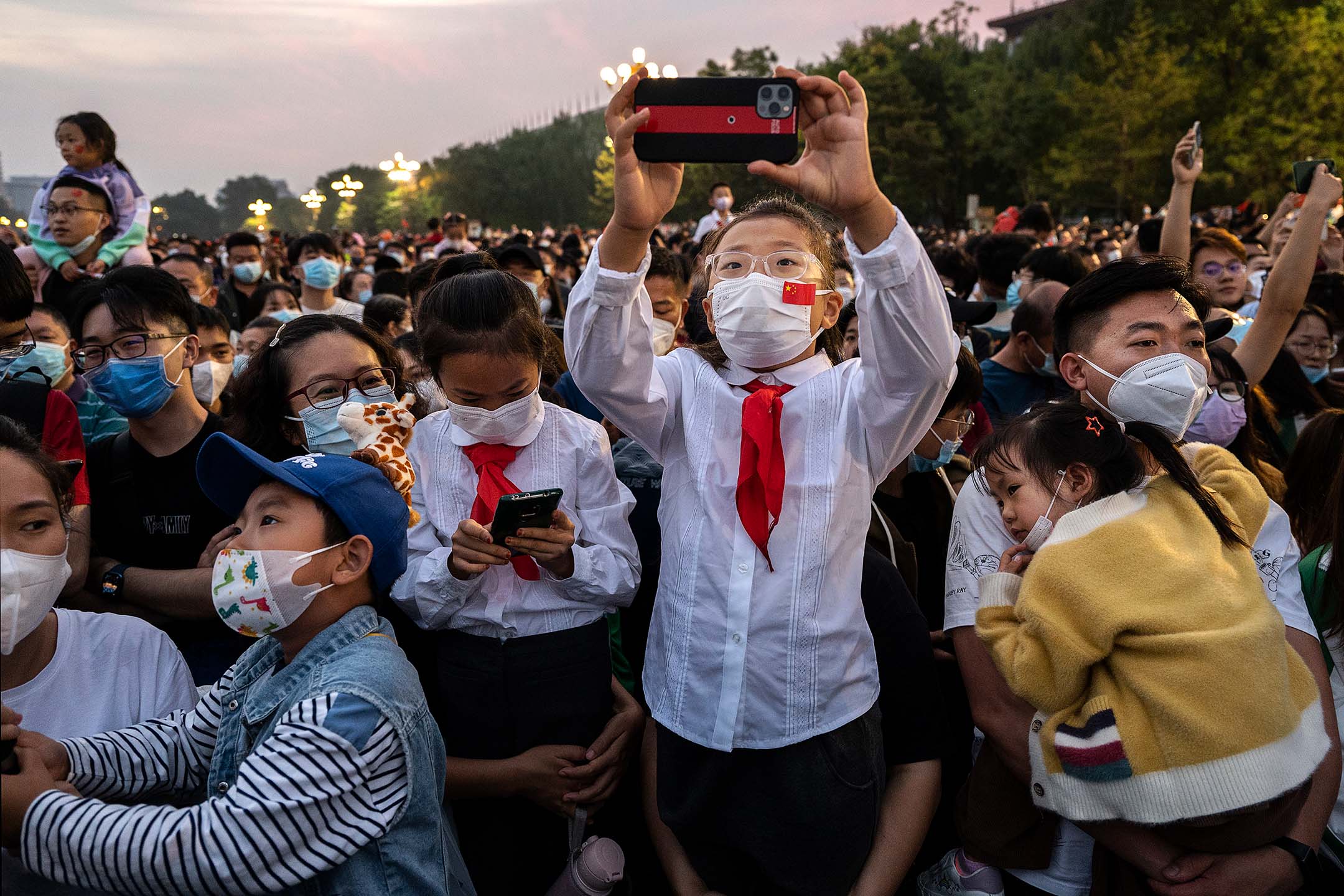 2022年10月1日，中国北京，孩子们穿著校服在天安门观看国庆升旗仪式。摄：Kevin Frayer/Getty Images