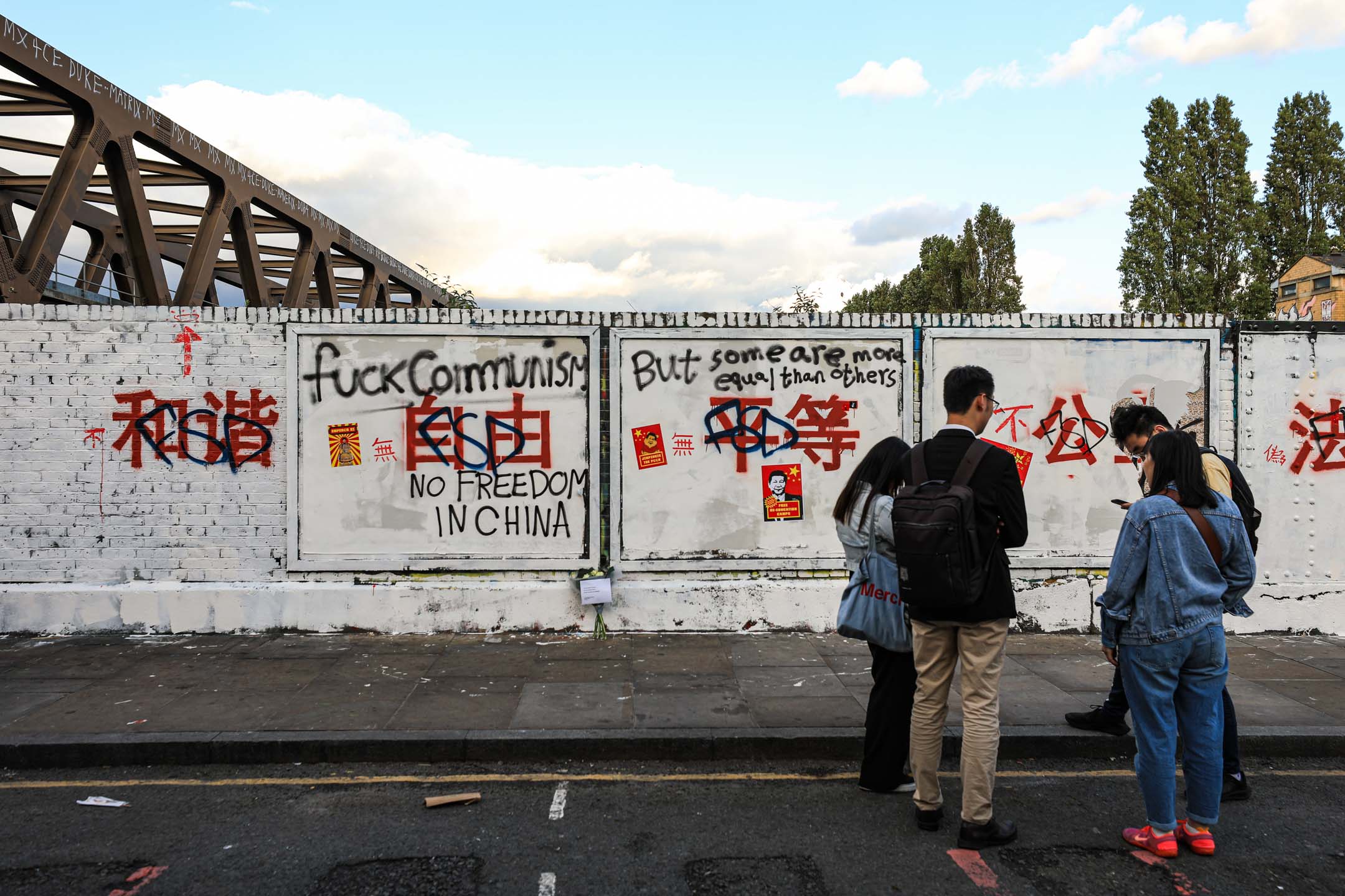 2023年8月6日,英国伦敦,中国共产党的口号出现在当地街头,吸引市民到场围观。摄:James Wendlinger/Getty Images