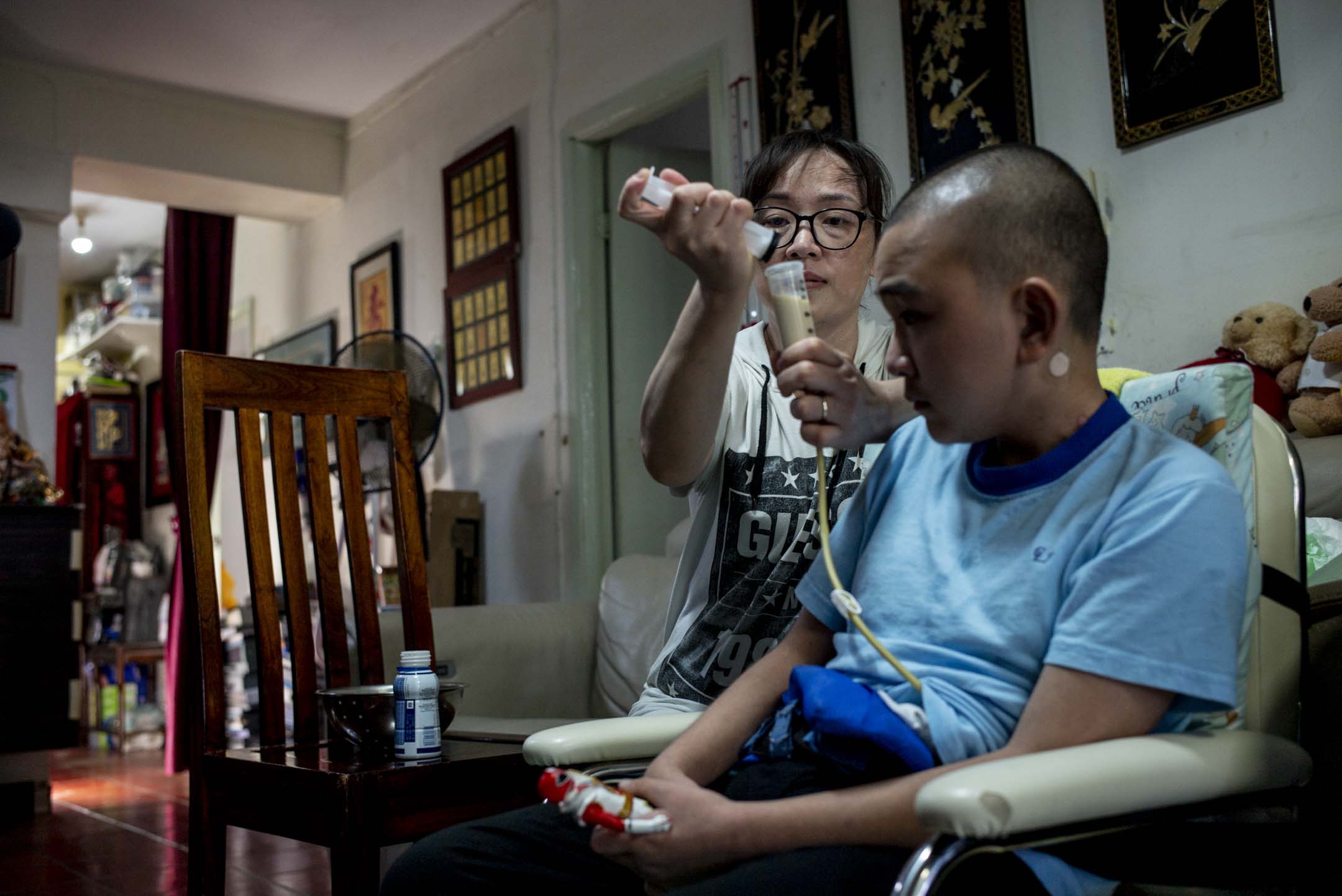 媽媽正在使用導管為家明餵食。攝:林振東/端傳媒