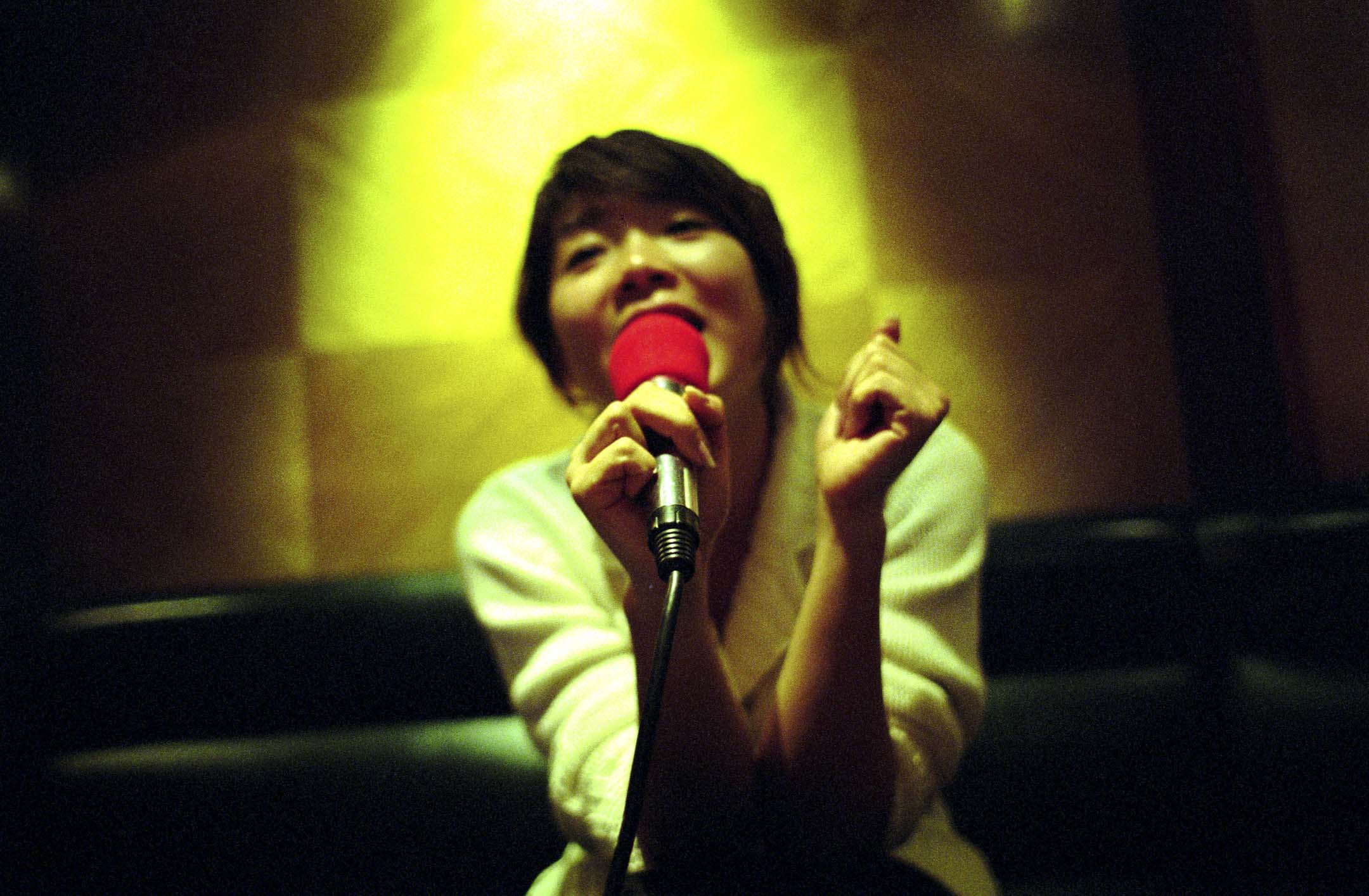 一位女士在卡拉 OK 唱著她最喜歡的歌曲。攝:Ryan Pyle/Corbis via Getty Images