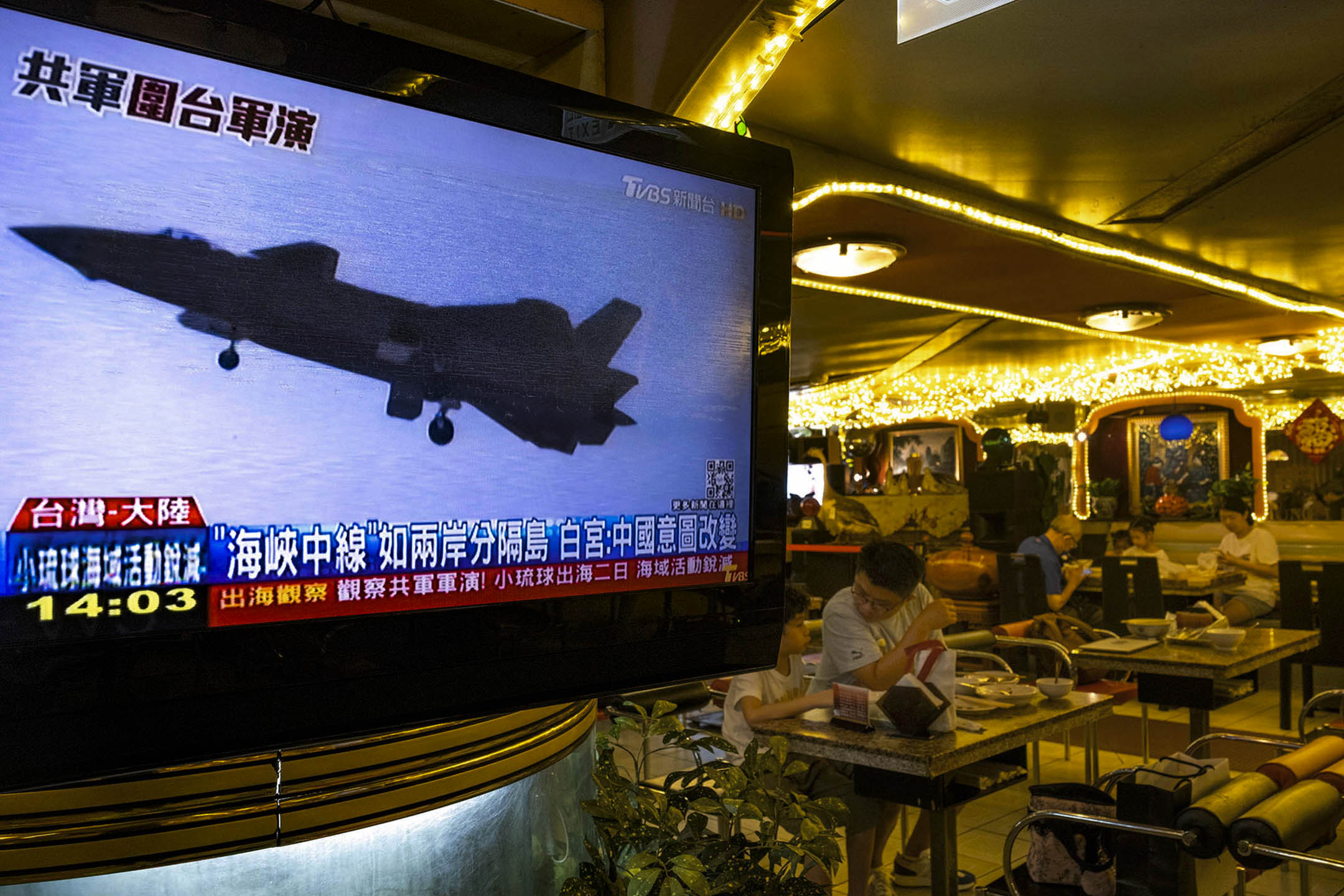 2022年8月5日,台北一间食肆的电视上播放中国在台湾周边进行军事演练的新闻。摄:陈焯𪸩/端传媒