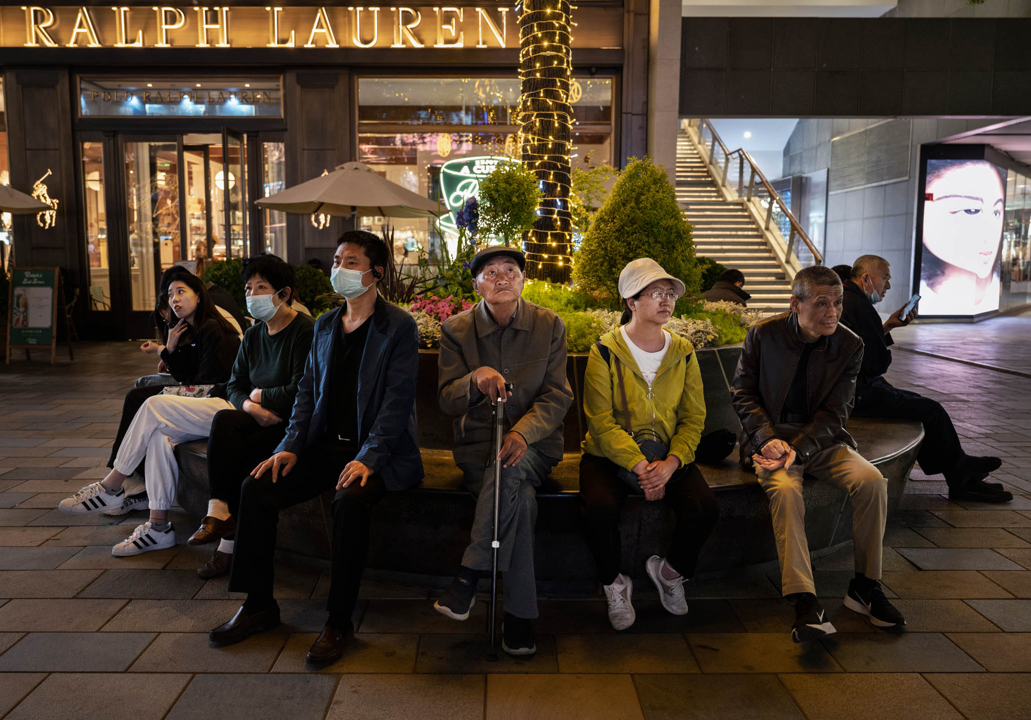 2023年4月18日，中國北京，市民坐在零售購物區的椅子上。攝：Kevin Frayer/Getty Images