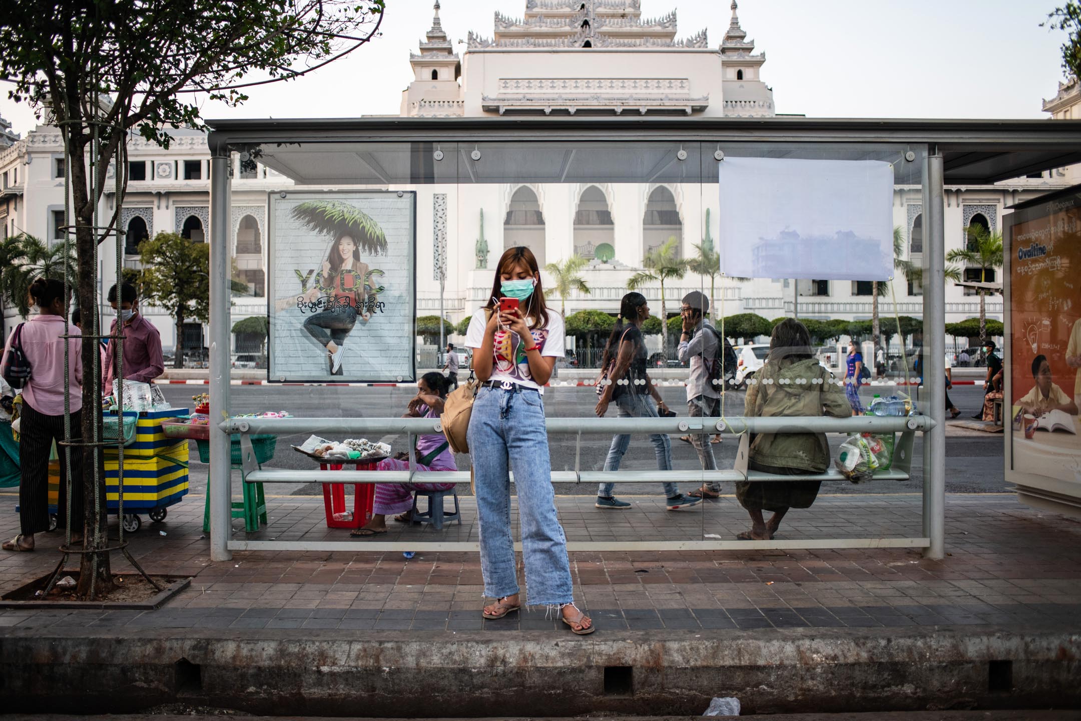 2020年3月24日,緬甸,一名女士在街道上看手機。攝:Shwe Paw Mya Tin/NurPhoto via Getty Images