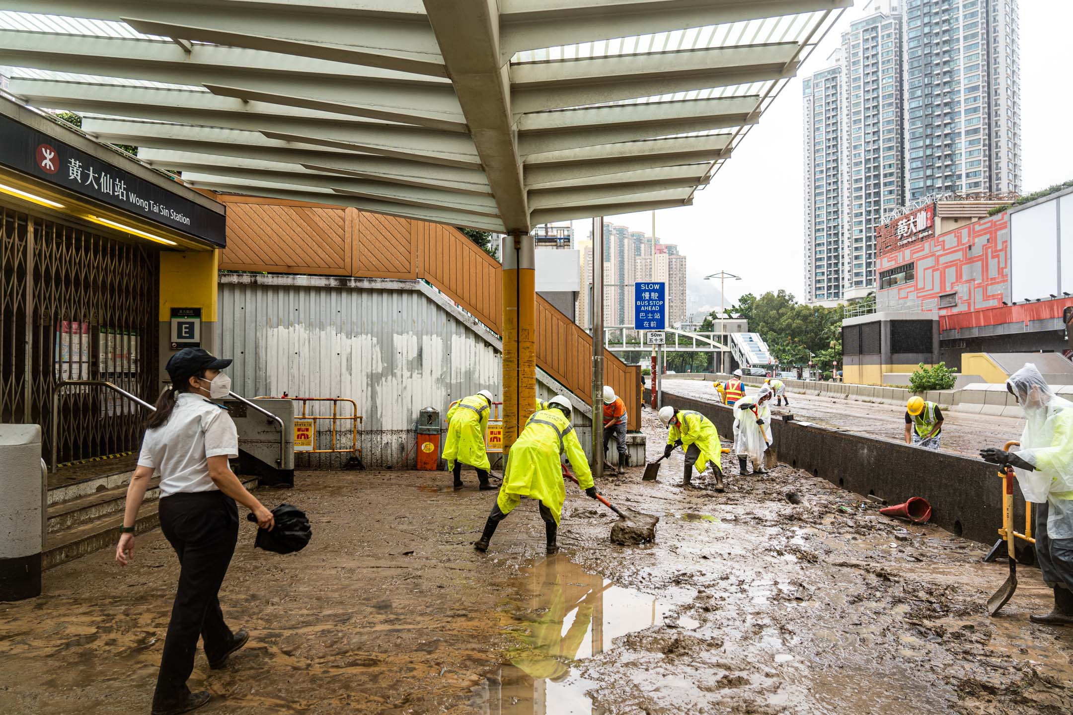 2023年9月8日,大暴雨过后,黄大仙地铁站出口外工人正在清理污泥。摄:Ryan Lai/端传媒
