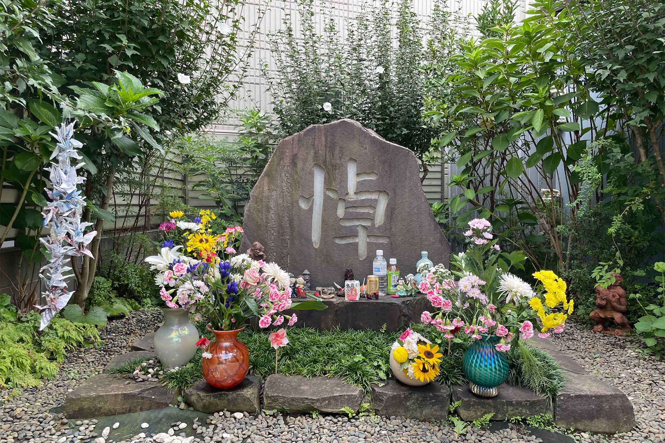 朝鮮半島移民過去的聚居處之一,荒川河岸,以及證言所指虐殺事件發生的河岸位置。致力於口述訪調及挖掘命喪荒川的朝鮮人遺骨的民間團體「鳳仙花之家」,幾經波折最後的落腳處也在荒川岸邊。充當辦公室的小屋,旁邊立起了追悼逝者的紀念碑。圖:作者提供。